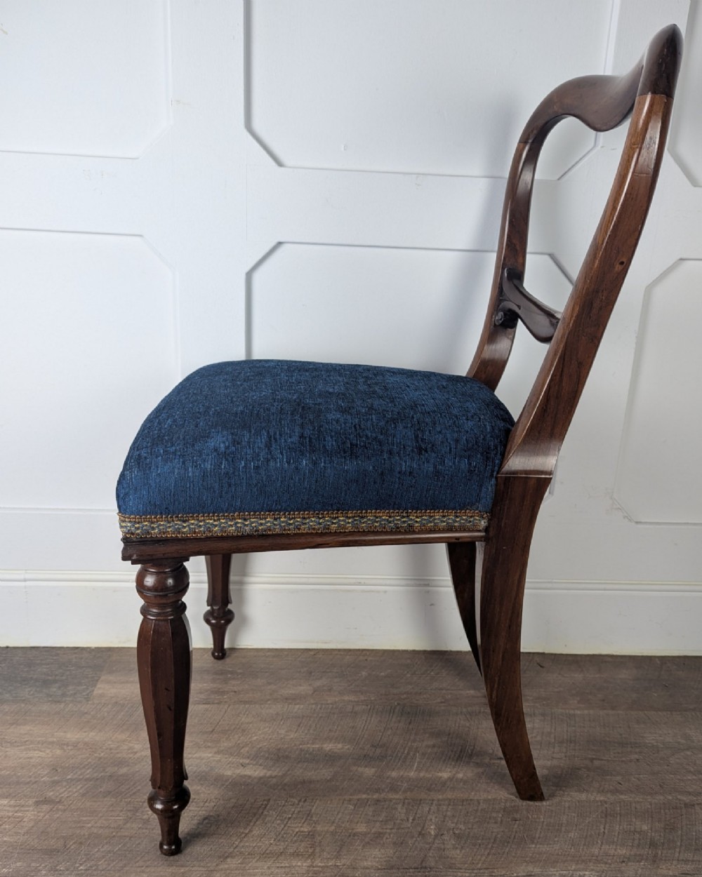 A Victorian rosewood side chair with a curved kidney backrest, turned front legs, and a navy blue velvet upholstered seat. View VIII