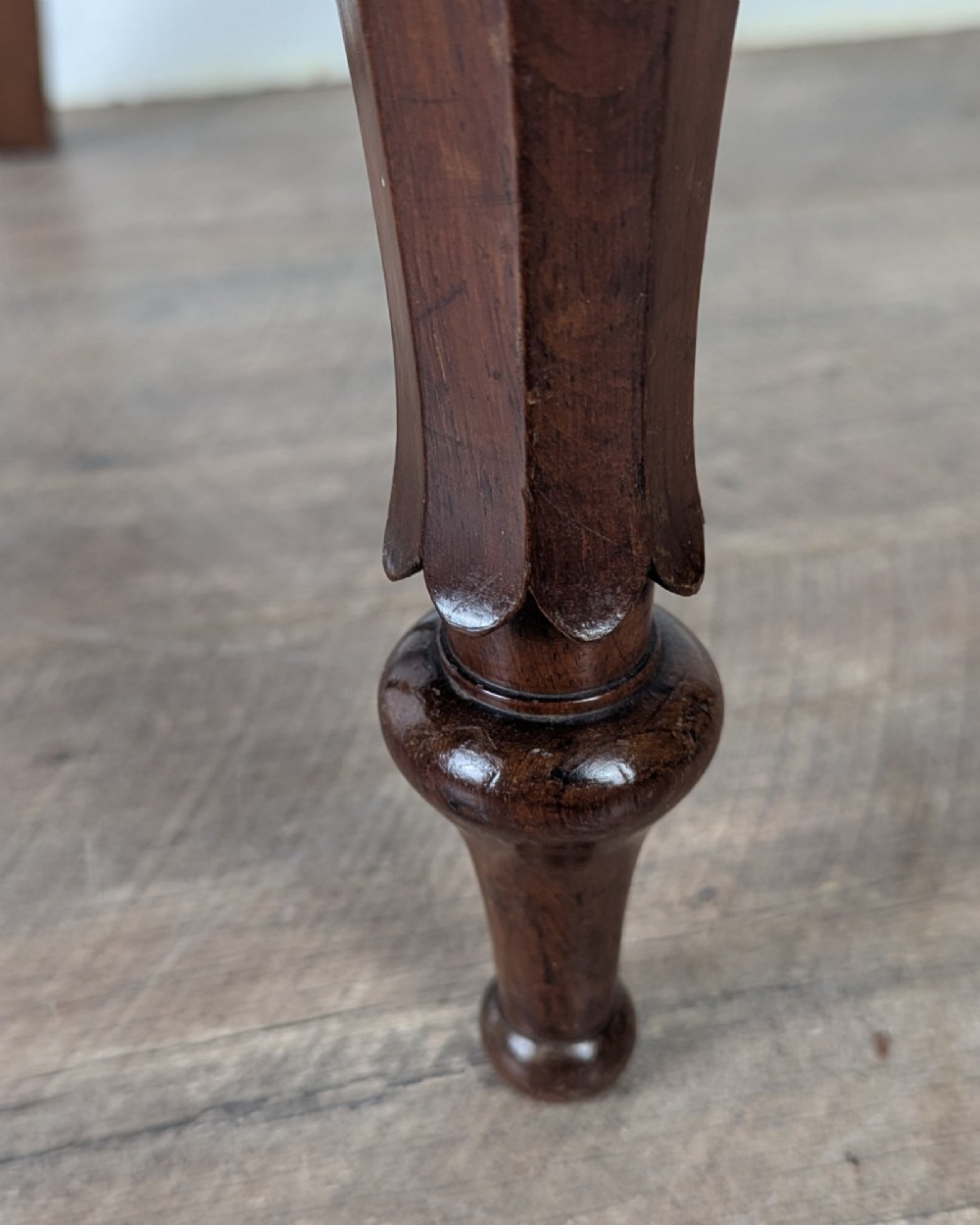 A Victorian rosewood side chair with a curved kidney backrest, turned front legs, and a navy blue velvet upholstered seat. View XII