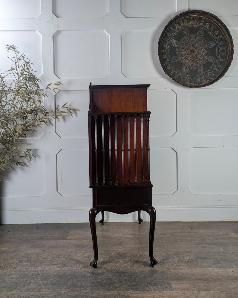 An early 20th-century mahogany music cabinet featuring a central glazed door flanked by turned spindle galleries, set above two drawers on cabriole legs. View V