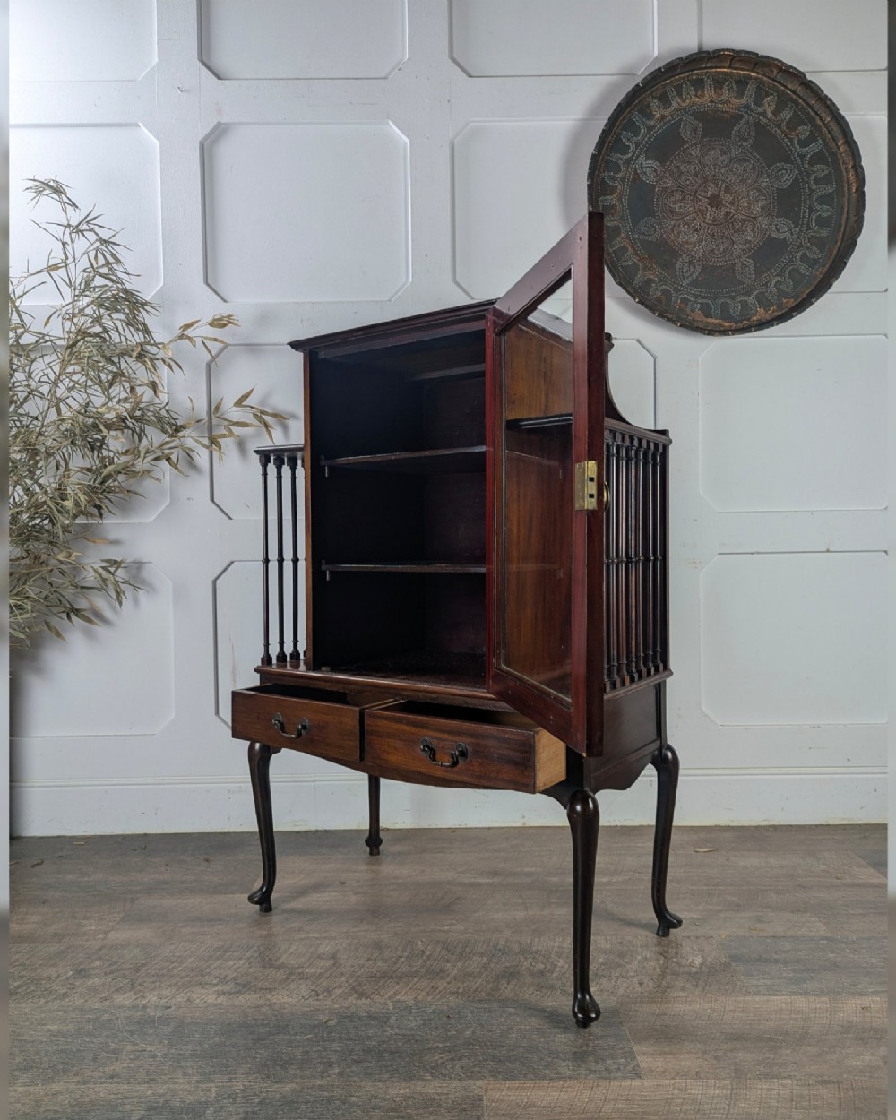 An early 20th-century mahogany music cabinet featuring a central glazed door flanked by turned spindle galleries, set above two drawers on cabriole legs. View VIII