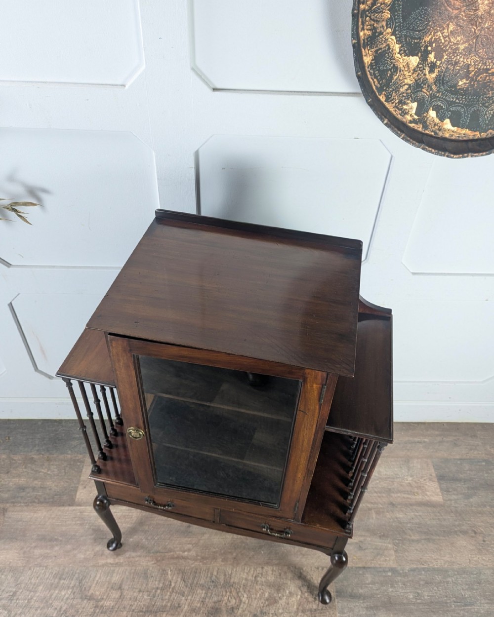 An early 20th-century mahogany music cabinet featuring a central glazed door flanked by turned spindle galleries, set above two drawers on cabriole legs. View XII