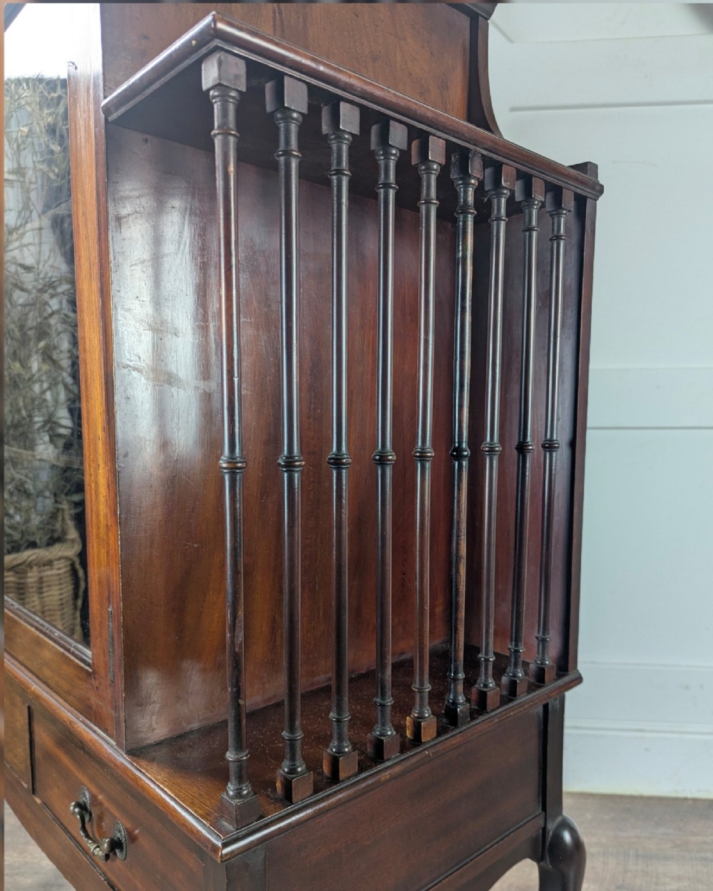 An early 20th-century mahogany music cabinet featuring a central glazed door flanked by turned spindle galleries, set above two drawers on cabriole legs. View XIV