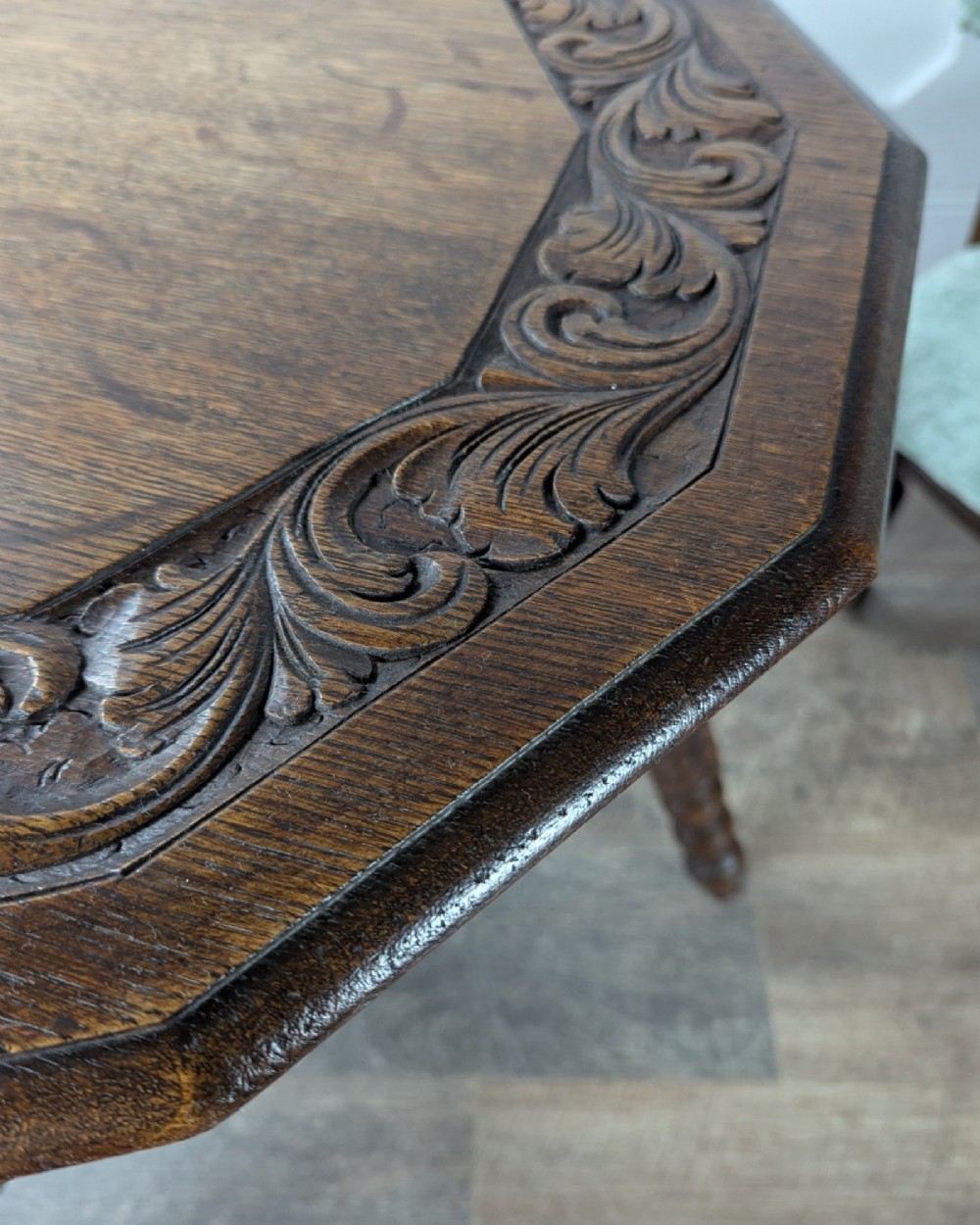 A late Victorian solid dark oak side table with an octagonal top, three barley twist legs, carved block knees, and a central turned finial on the stretcher base. View IV