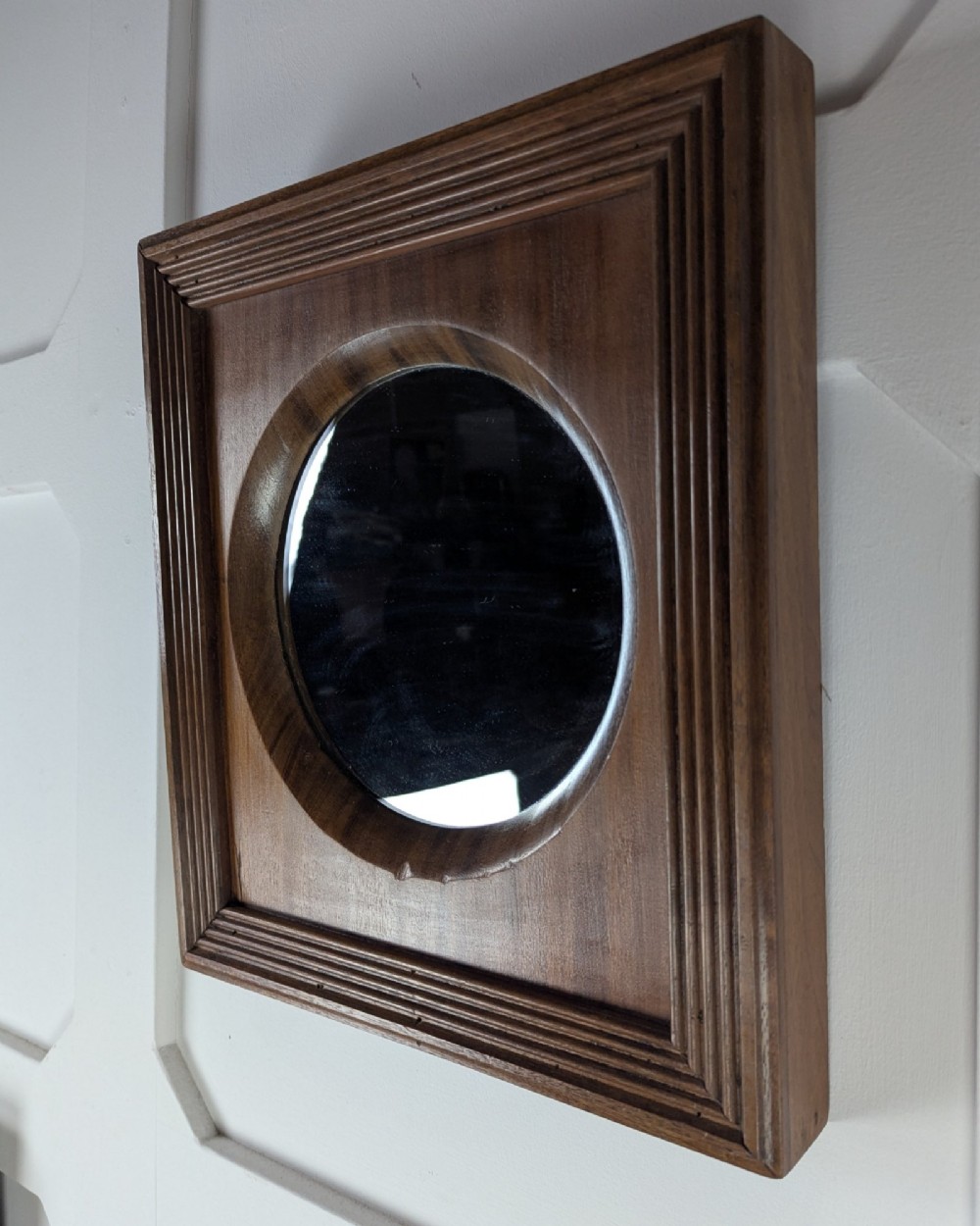 A square dark mahogany frame featuring stepped outer mouldings and a central circular mirror reflection. View III