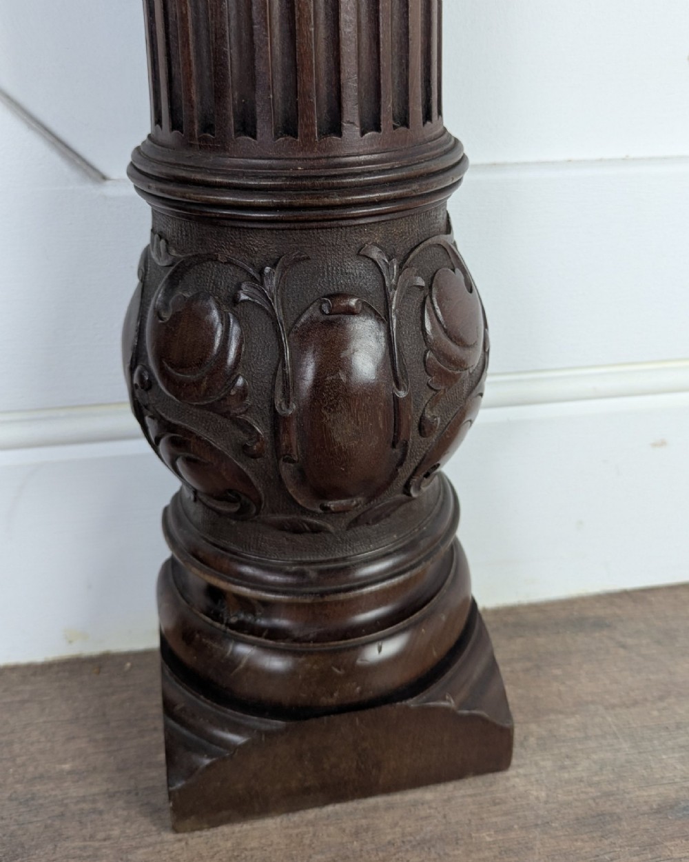 A pair of dark carved mahogany half columns featuring Corinthian capitals, reeded shafts, and carved bulbous bases. View IV