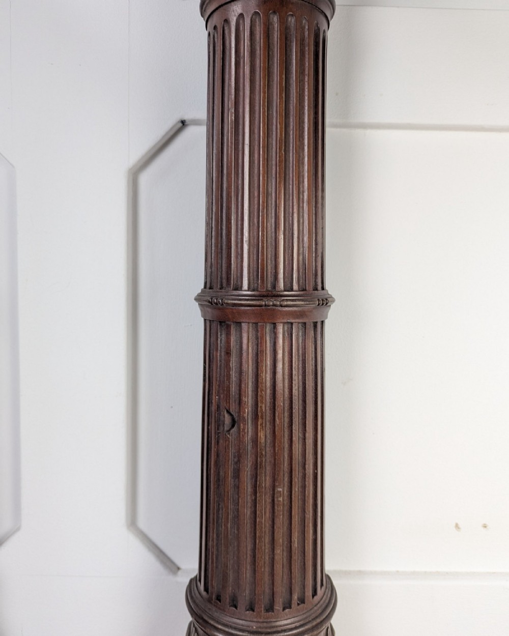 A pair of dark carved mahogany half columns featuring Corinthian capitals, reeded shafts, and carved bulbous bases. View VII
