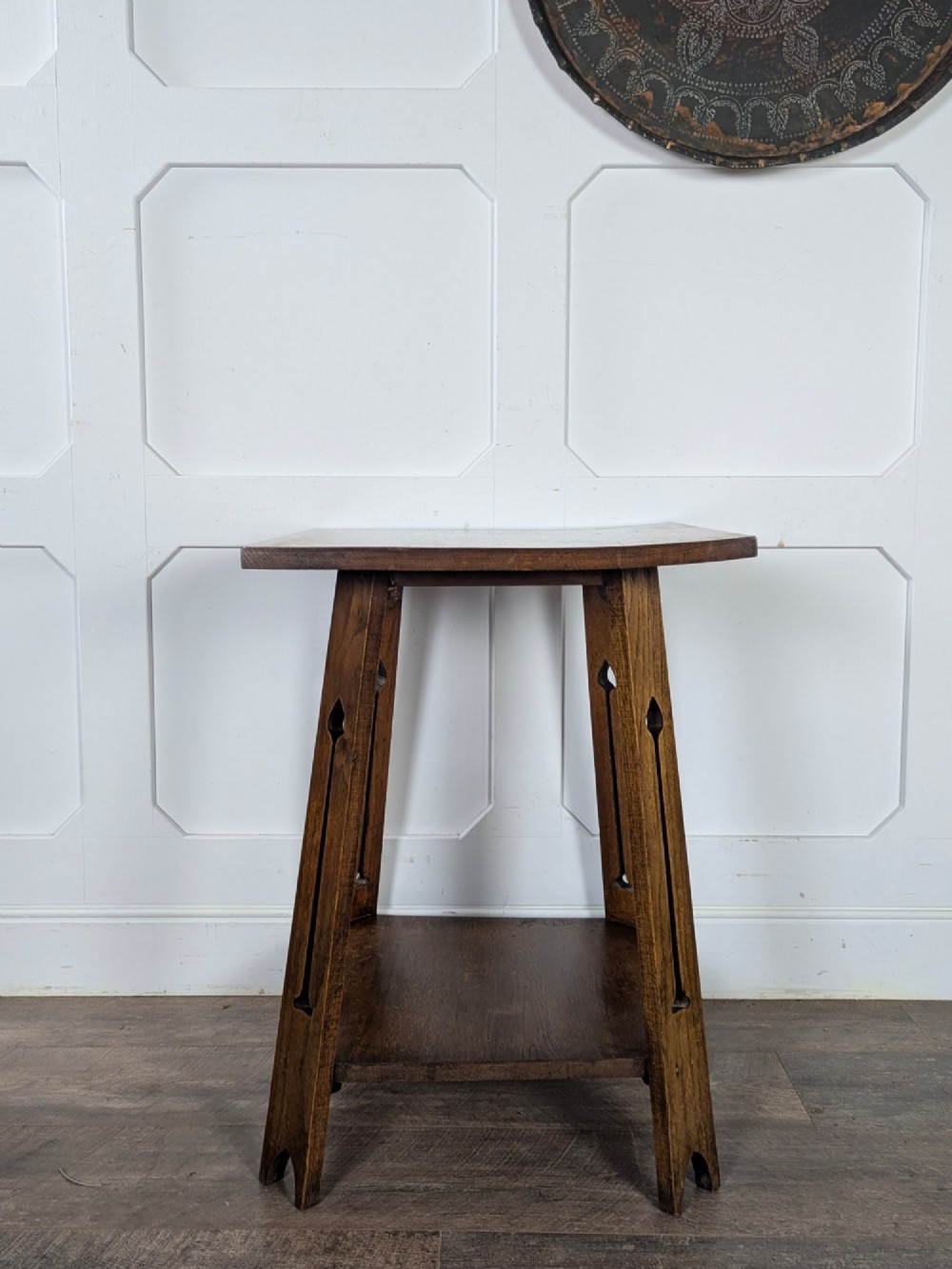 A solid oak Art Nouveau side table featuring splayed legs with spade-shaped cutouts and a lower square undertier shelf. View IV