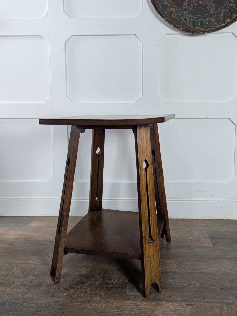 A solid oak Art Nouveau side table featuring splayed legs with spade-shaped cutouts and a lower square undertier shelf. View V