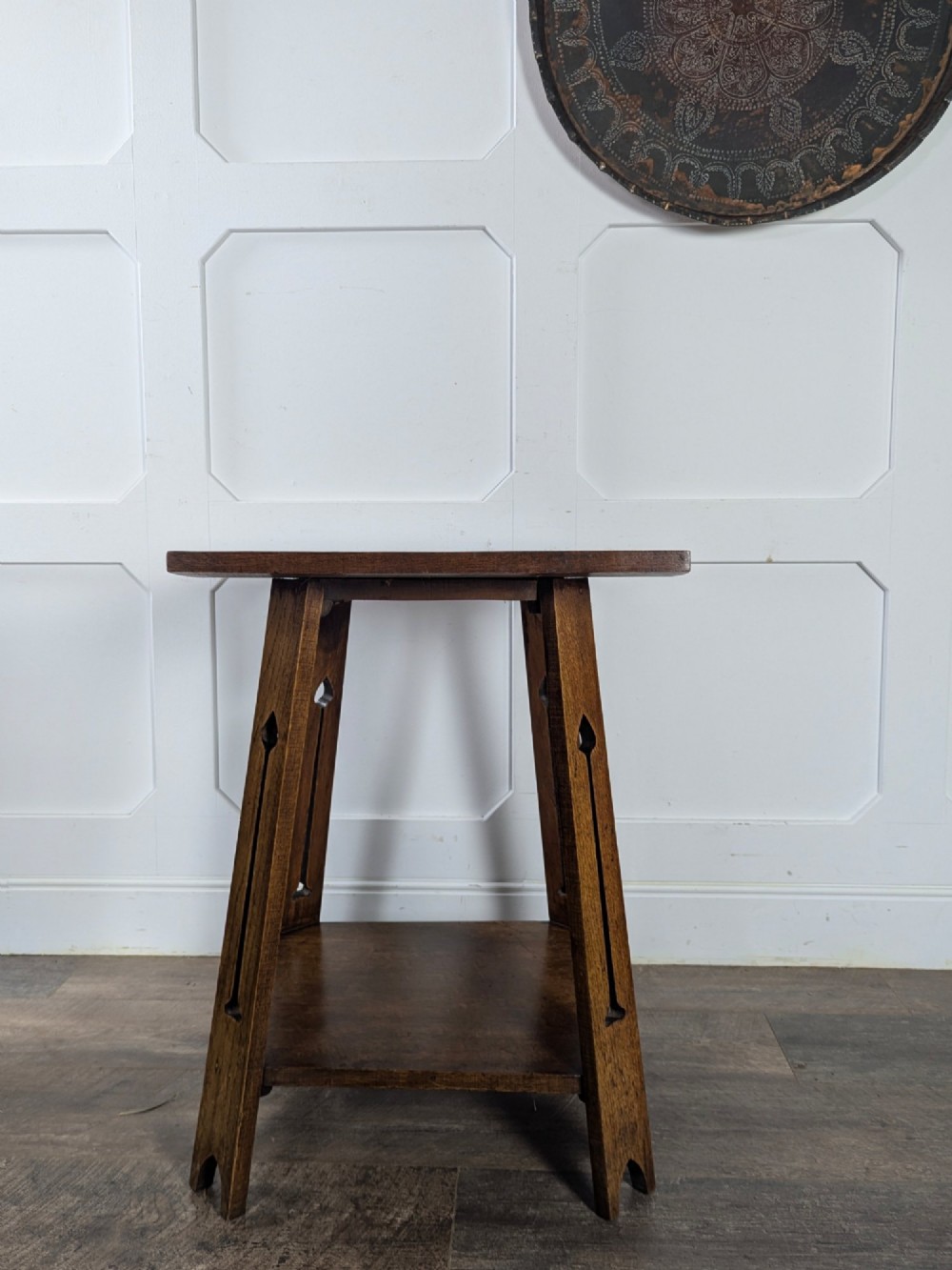 A solid oak Art Nouveau side table featuring splayed legs with spade-shaped cutouts and a lower square undertier shelf. View VI