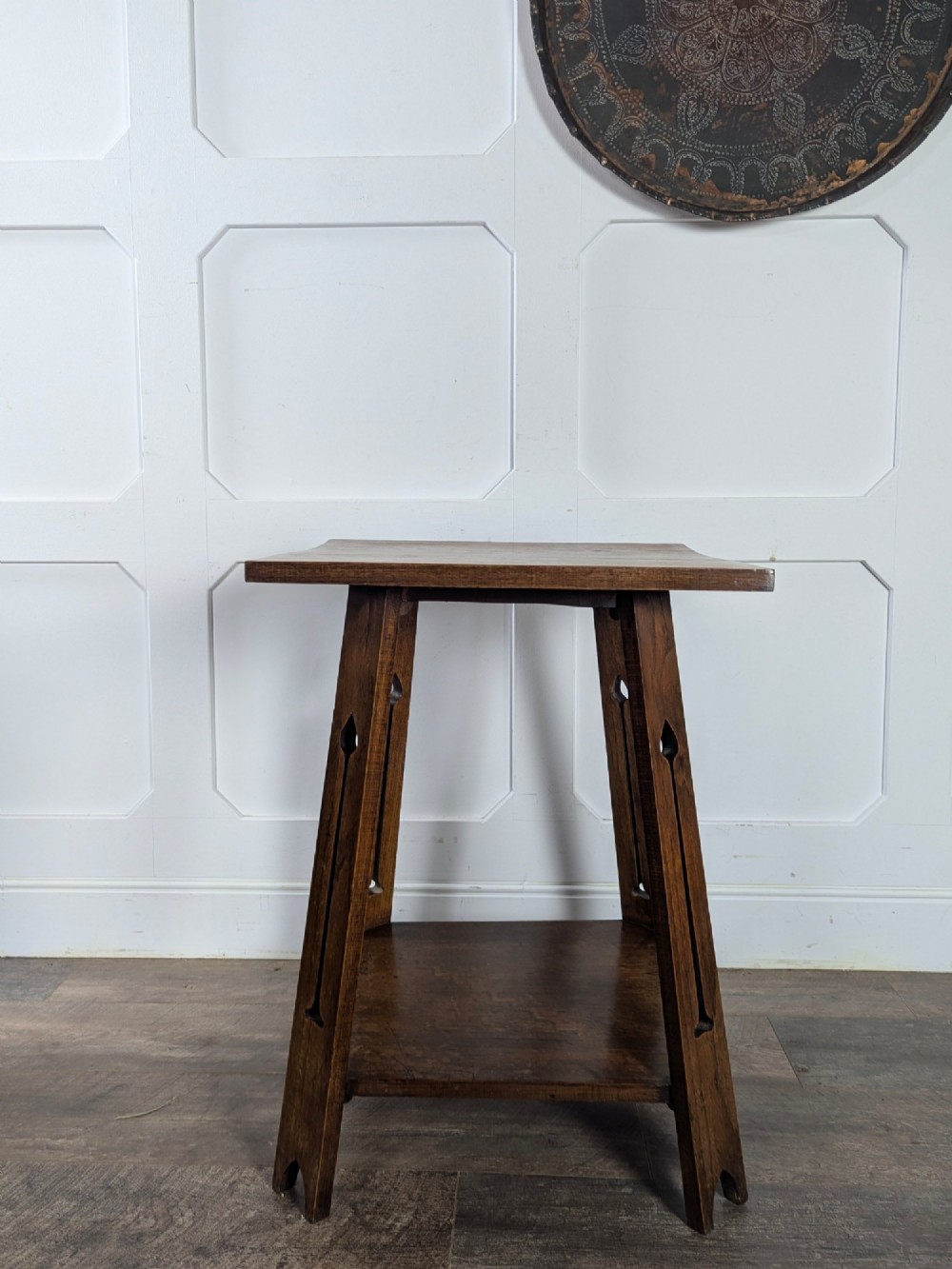 A solid oak Art Nouveau side table featuring splayed legs with spade-shaped cutouts and a lower square undertier shelf. View VIII