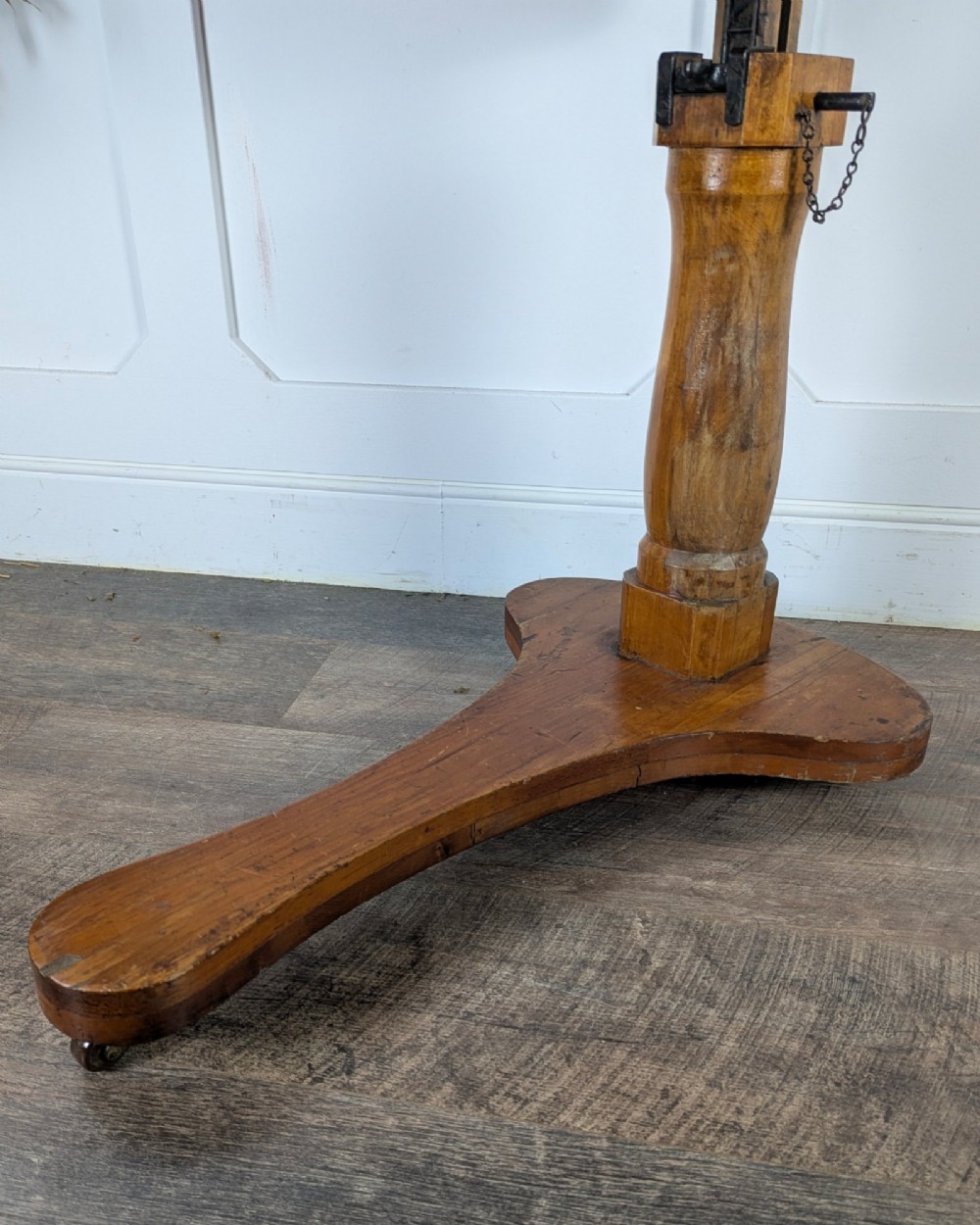 An early 20th-century pine reading table featuring an adjustable tilting top, a central turned support column, and a shaped base on small castors. View IX