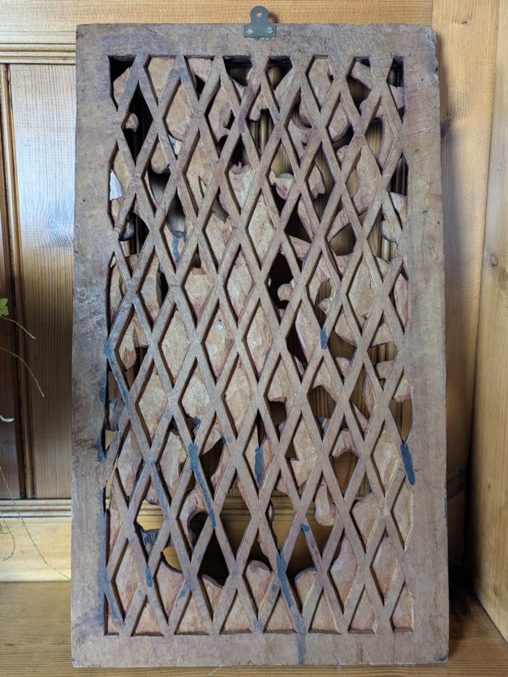 A rectangular dark teak wall panel hand-carved in high relief with an openwork Balinese mythological figure framed by intricate scrolling foliage. View VII