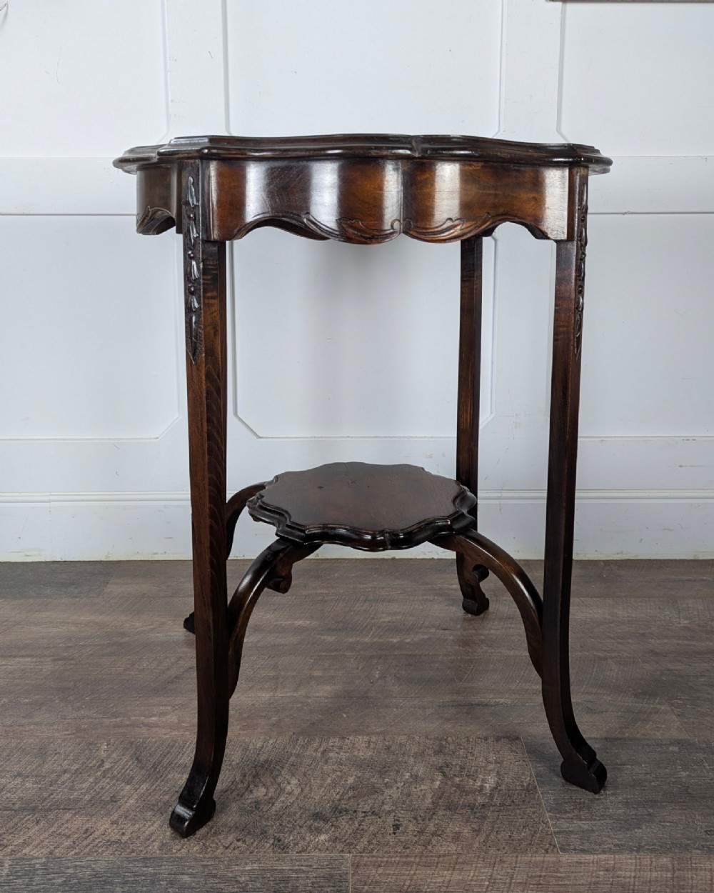 An early 20th-century walnut side table featuring a scalloped rim, carved legs, and a lower undertier shelf. View IV