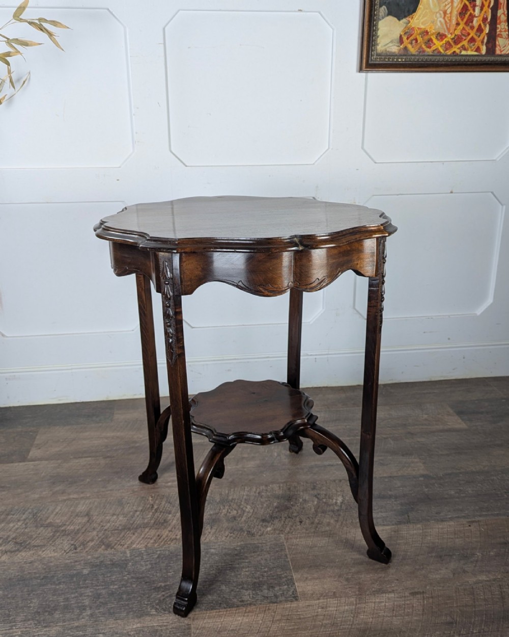 An early 20th-century walnut side table featuring a scalloped rim, carved legs, and a lower undertier shelf. View VI