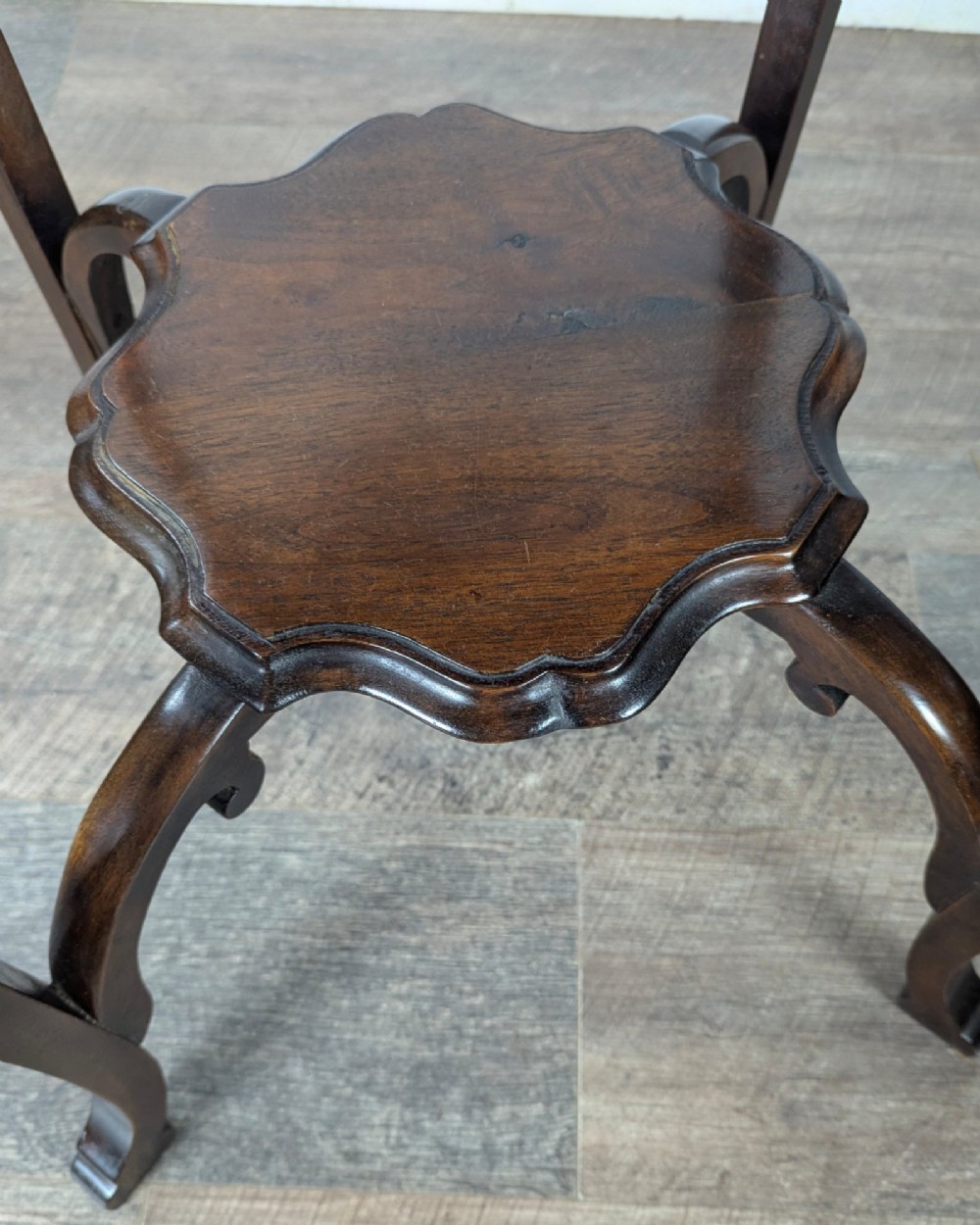 An early 20th-century walnut side table featuring a scalloped rim, carved legs, and a lower undertier shelf. View XI