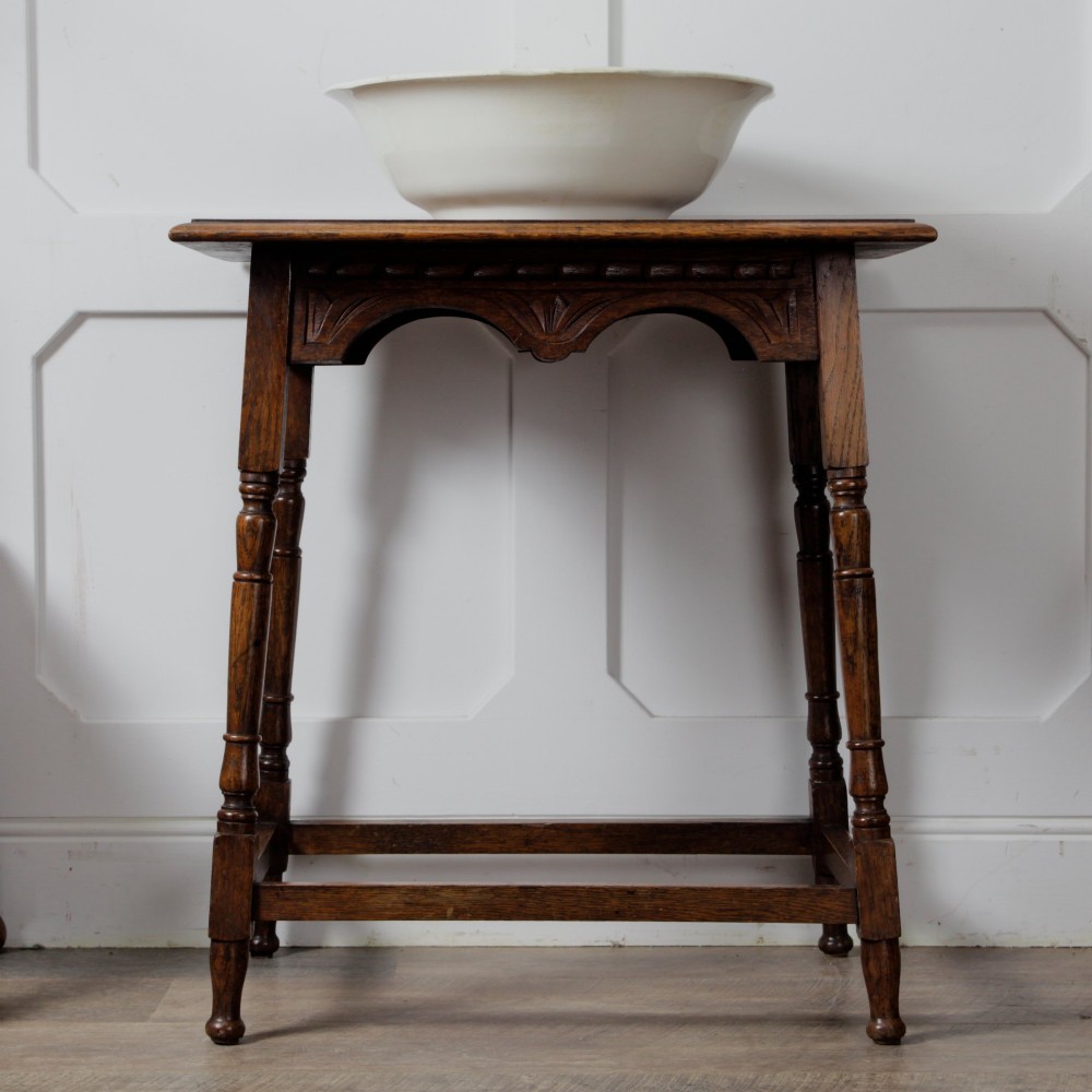 A late Victorian solid oak side table featuring carved apron arches, turned legs, and a rectangular top supported by low box stretchers. View IV