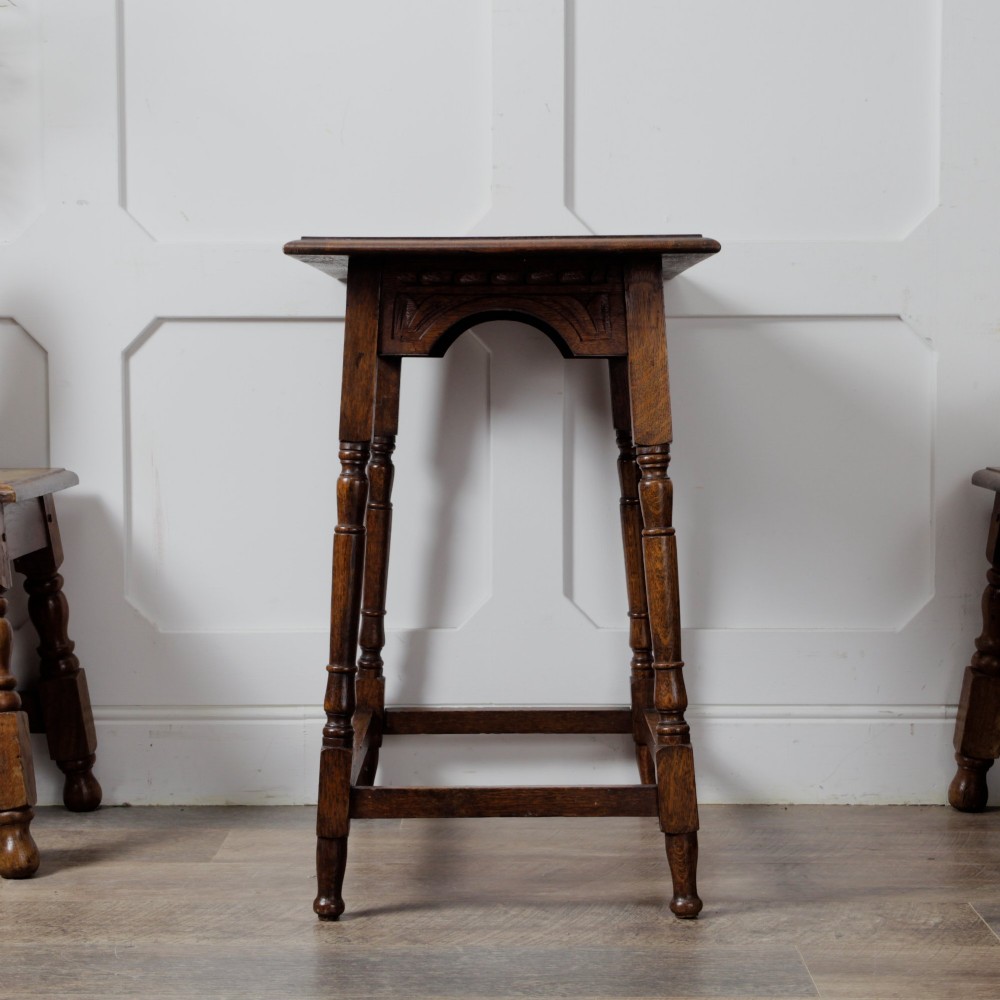 A late Victorian solid oak side table featuring carved apron arches, turned legs, and a rectangular top supported by low box stretchers. View VII