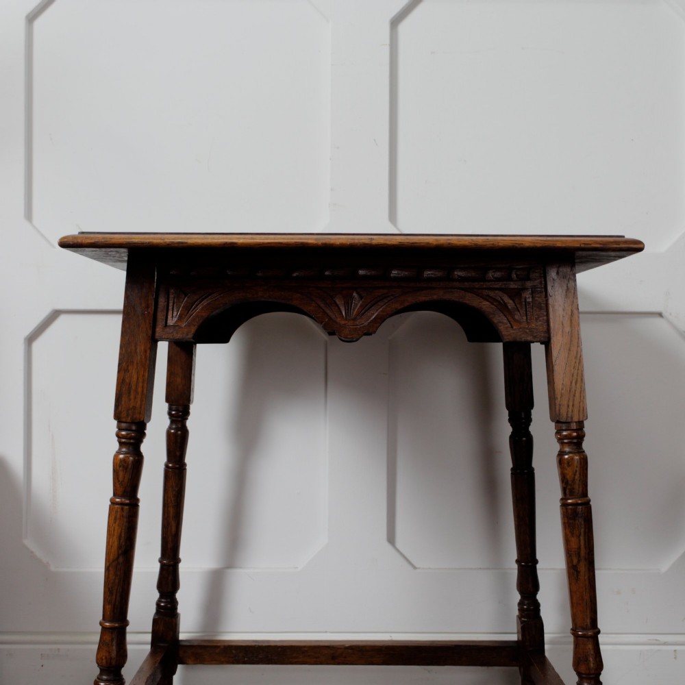 A late Victorian solid oak side table featuring carved apron arches, turned legs, and a rectangular top supported by low box stretchers. View VIII