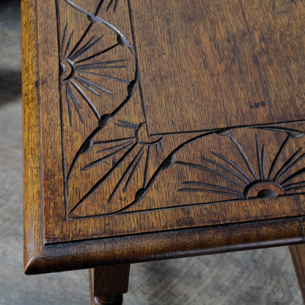 A late Victorian solid oak side table featuring carved apron arches, turned legs, and a rectangular top supported by low box stretchers. View IX