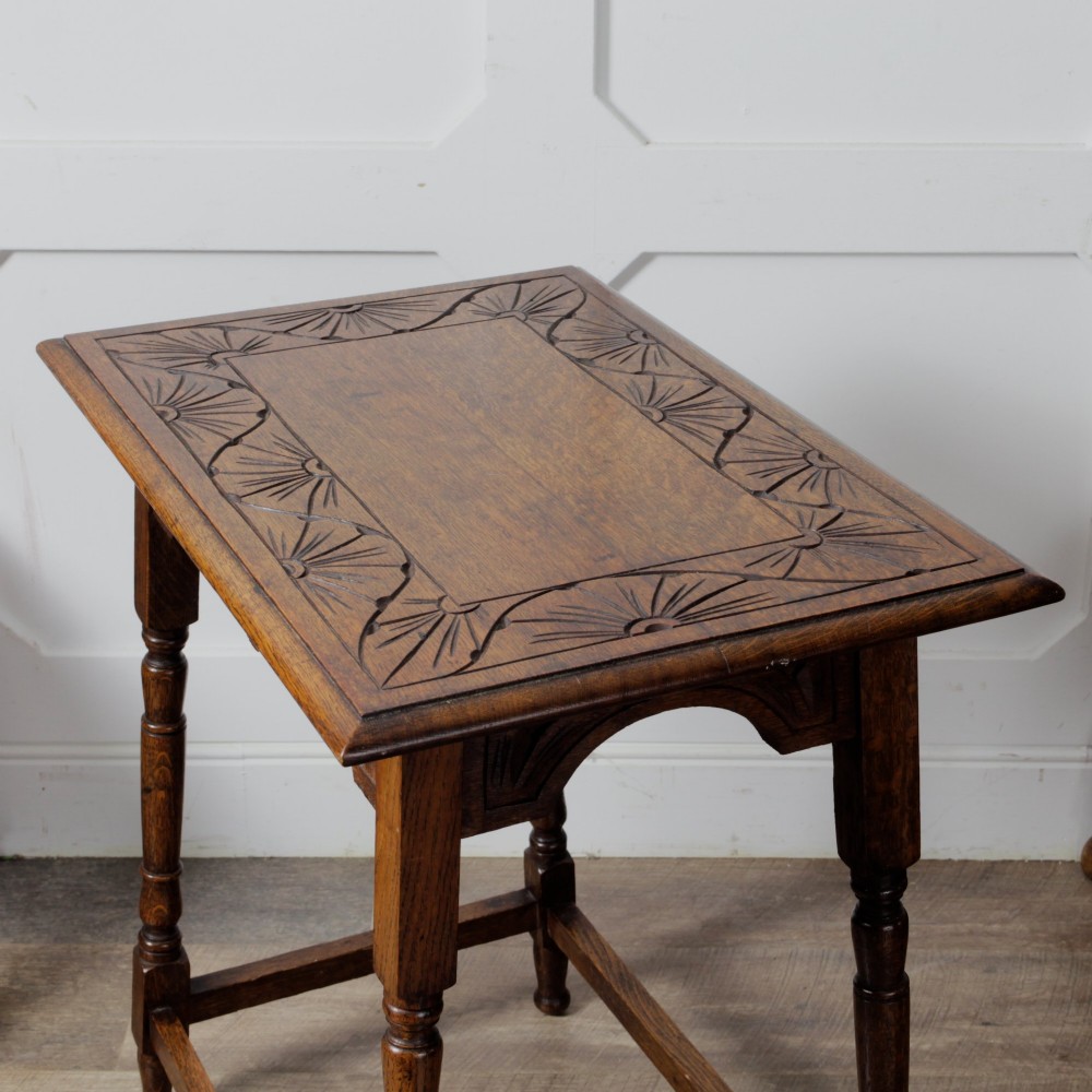 A late Victorian solid oak side table featuring carved apron arches, turned legs, and a rectangular top supported by low box stretchers. View X