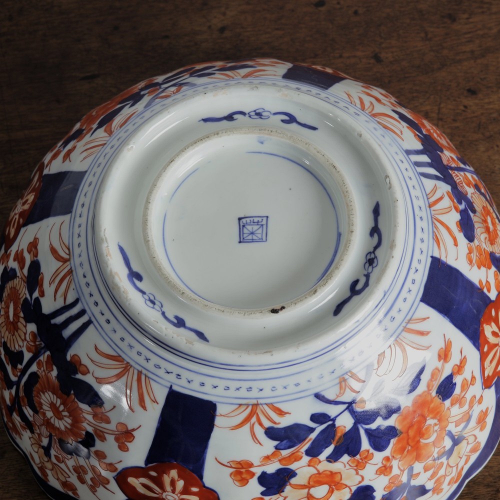 A round Japanese Imari porcelain bowl featuring scalloped edges and hand-painted floral motifs in cobalt blue, iron red, and white. View VIII