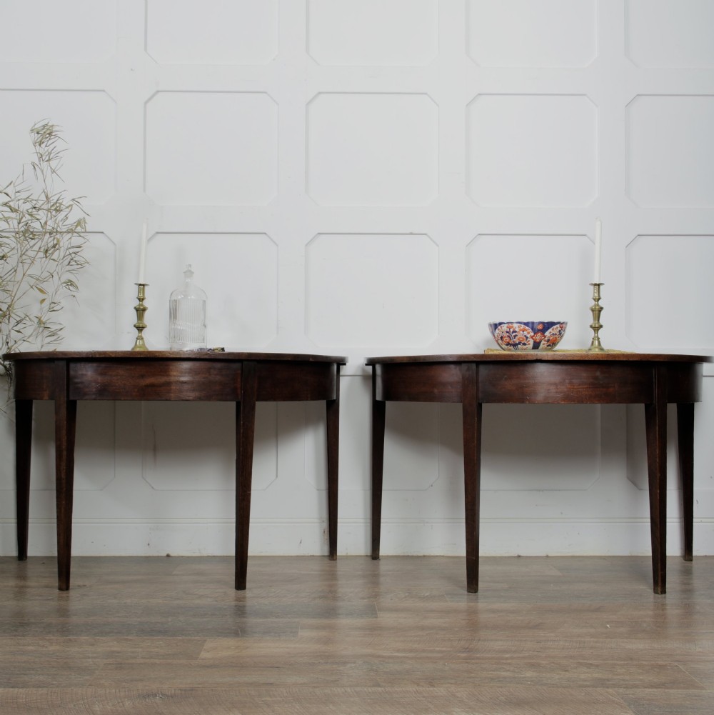 A pair of Georgian walnut demilune tables placed together to form a single round top with tapered legs. View V