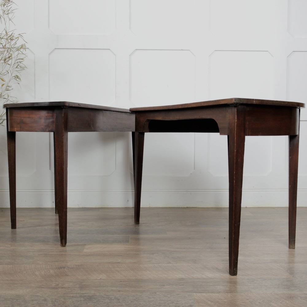 A pair of Georgian walnut demilune tables placed together to form a single round top with tapered legs. View VIII