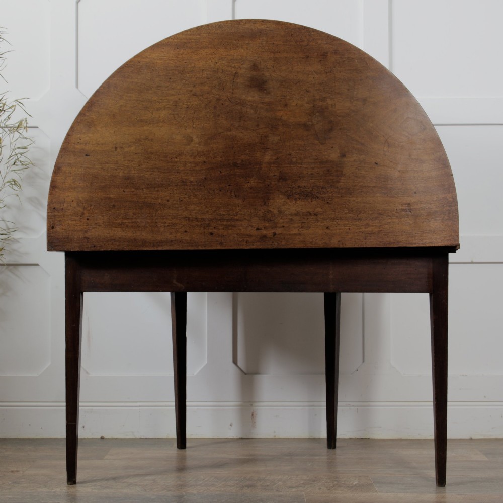 A pair of Georgian walnut demilune tables placed together to form a single round top with tapered legs. View IX