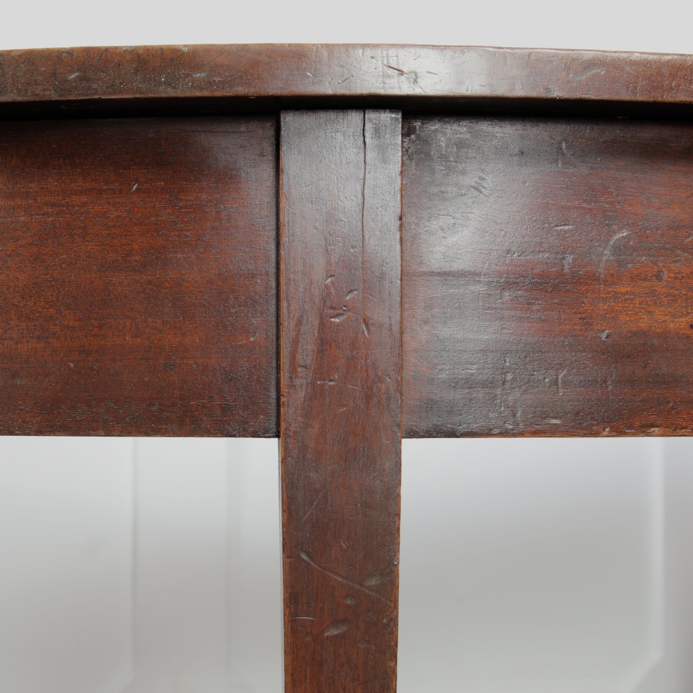 A pair of Georgian walnut demilune tables placed together to form a single round top with tapered legs. View XII