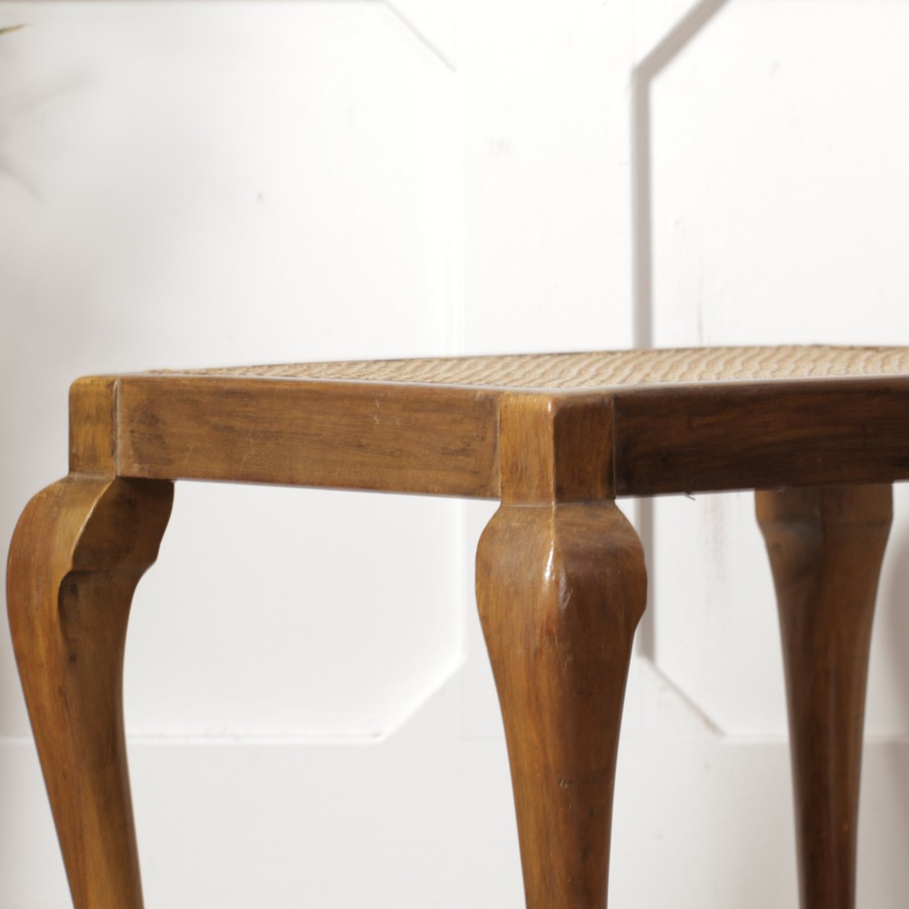 A low walnut luggage stand featuring a rectangular woven rattan top supported by four cabriole legs with pad feet. View VII