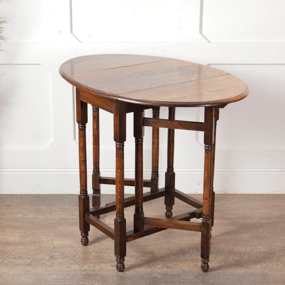 A small oak gateleg side table with turned legs, drop-down side flaps, and a warm brown wood finish. View V