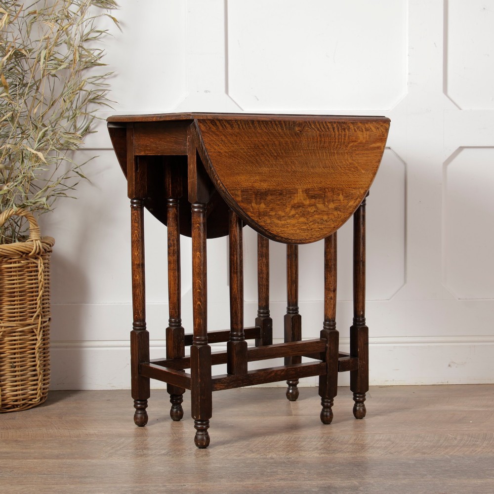 A small oak gateleg side table with turned legs, drop-down side flaps, and a warm brown wood finish. View VI