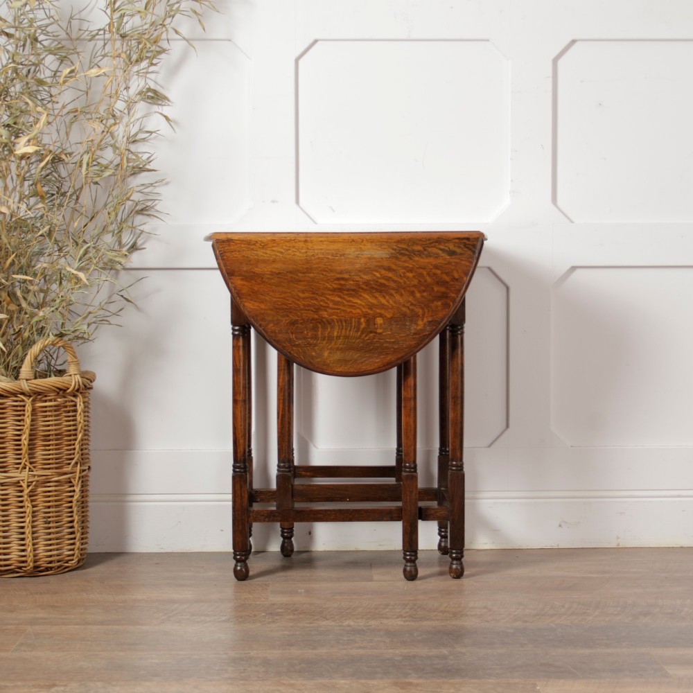 A small oak gateleg side table with turned legs, drop-down side flaps, and a warm brown wood finish. View VII