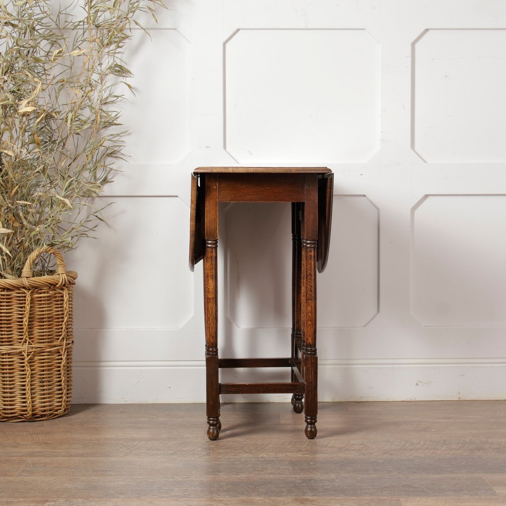 A small oak gateleg side table with turned legs, drop-down side flaps, and a warm brown wood finish. View VIII