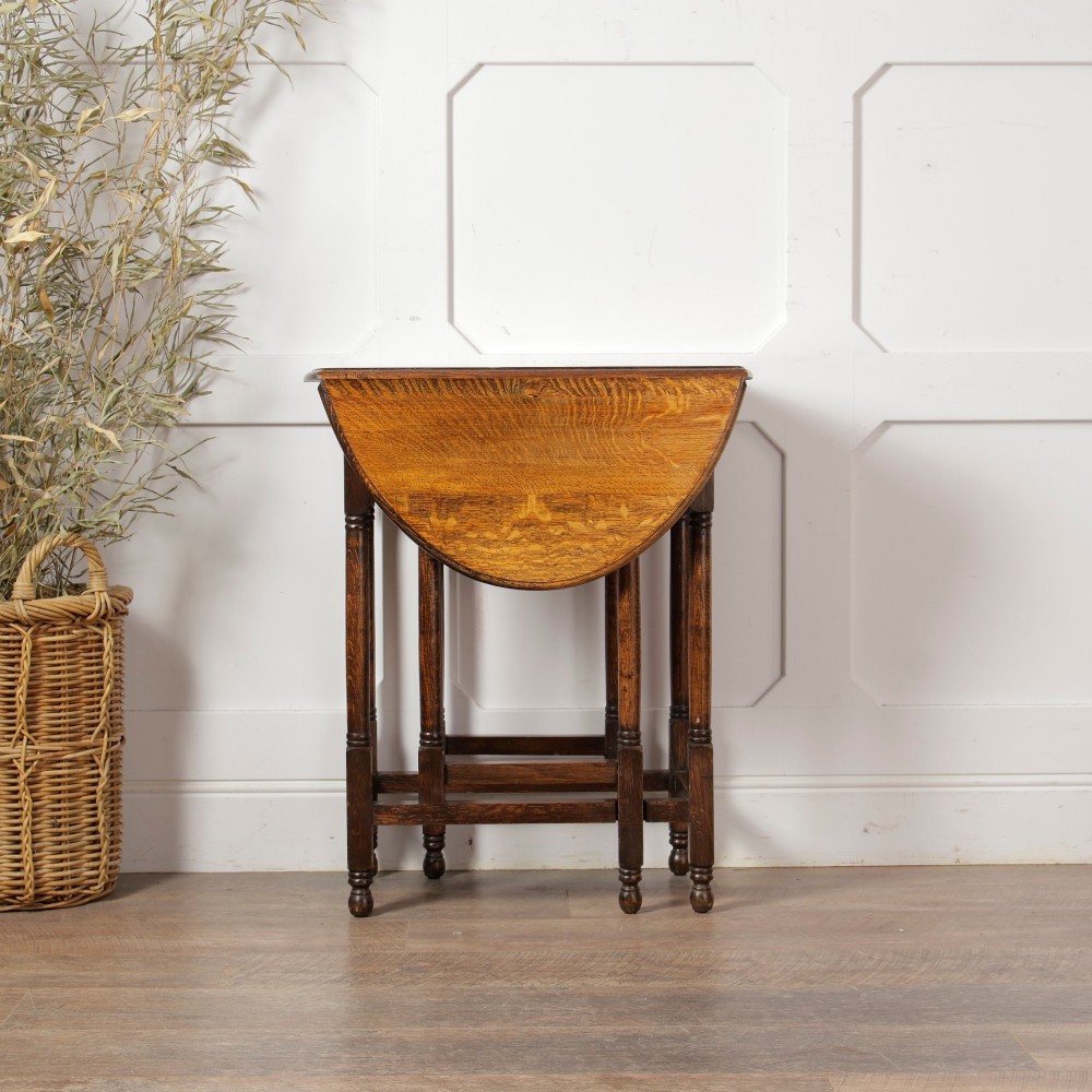 A small oak gateleg side table with turned legs, drop-down side flaps, and a warm brown wood finish. View IX