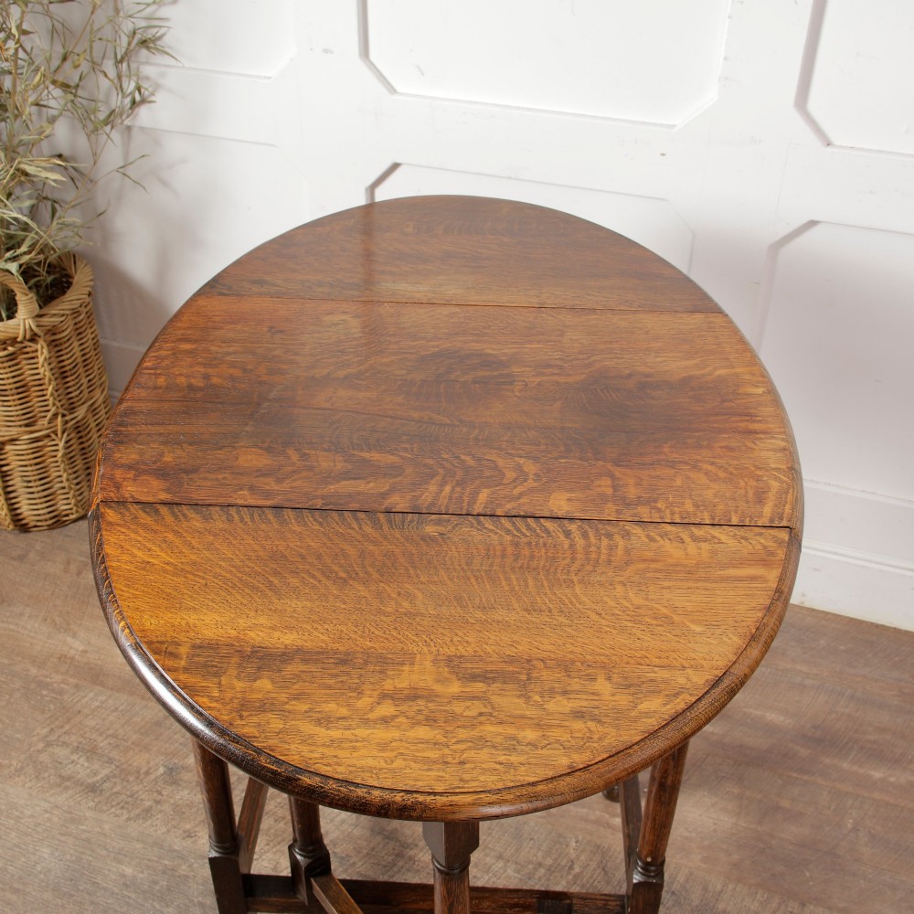 A small oak gateleg side table with turned legs, drop-down side flaps, and a warm brown wood finish. View XI