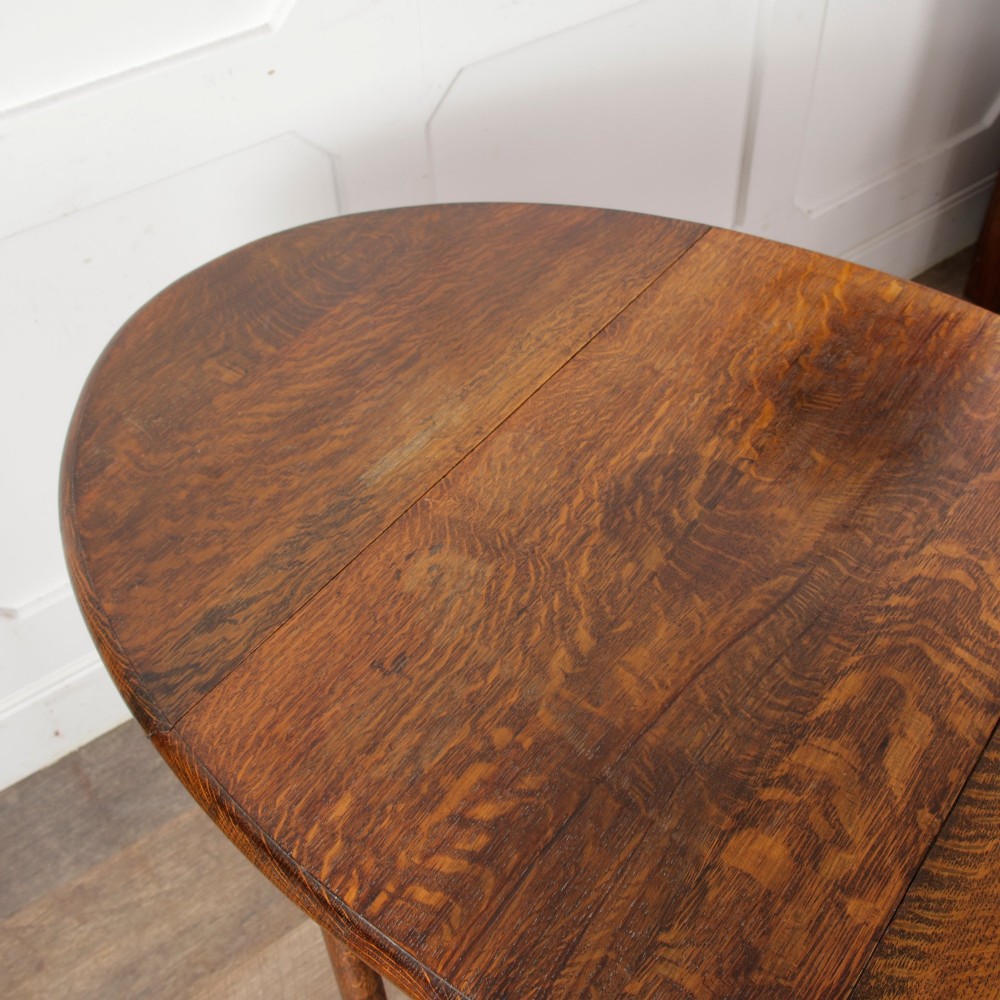 A small oak gateleg side table with turned legs, drop-down side flaps, and a warm brown wood finish. View XII