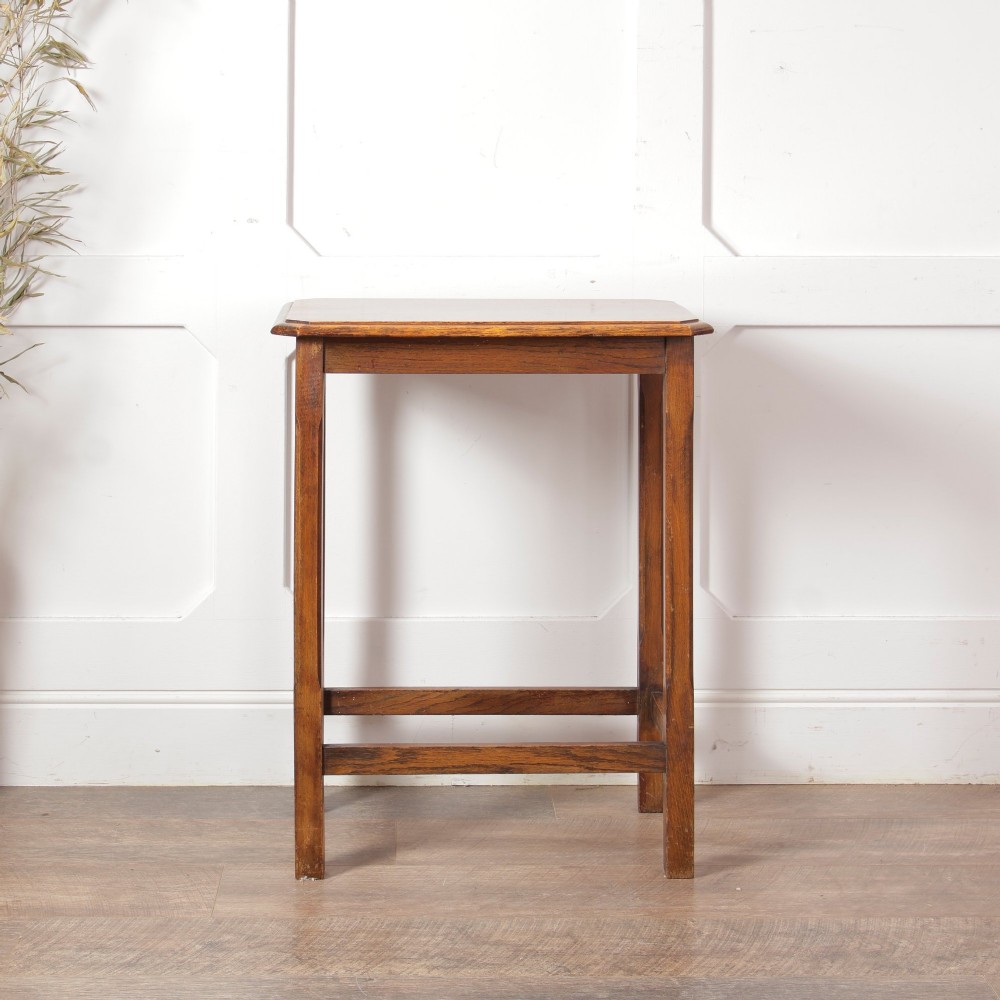 A rectangular warm brown oak side table featuring chamfered legs, bevelled top edges, and lower support stretchers.