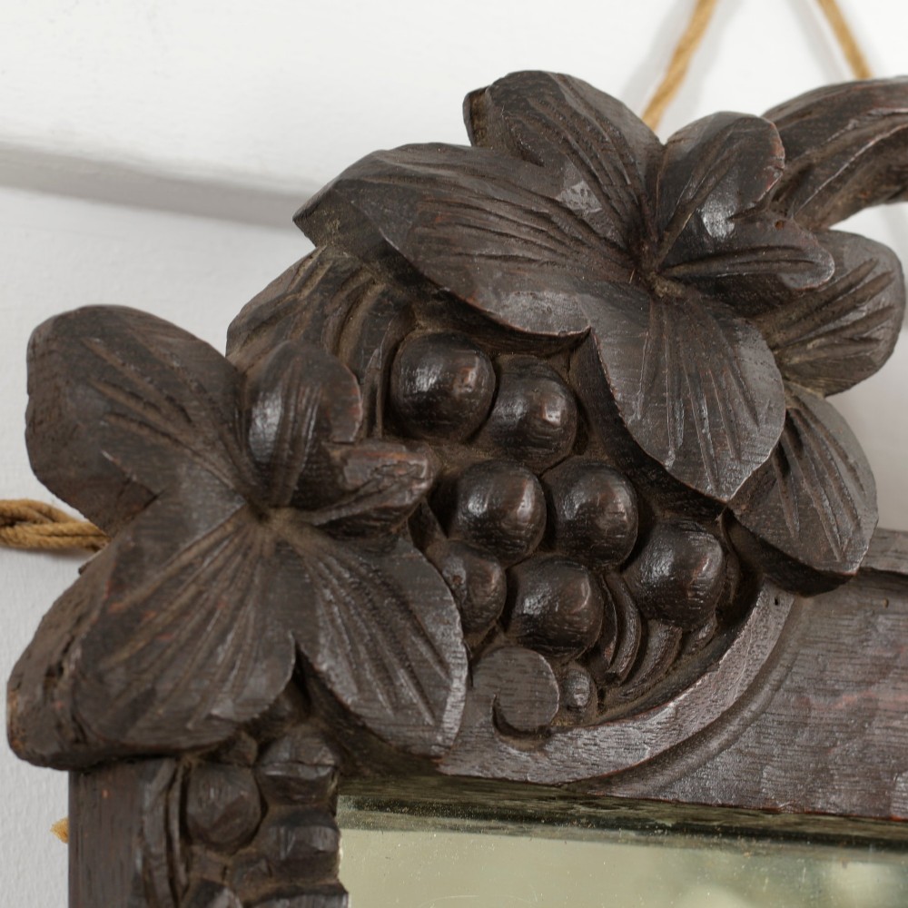 A rectangular nineteenth-century dark oak wall mirror featuring hand-carved leaf and grape motifs around the wooden frame. View VI