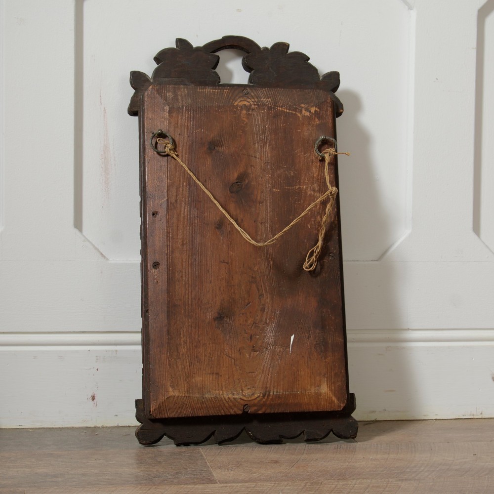 A rectangular nineteenth-century dark oak wall mirror featuring hand-carved leaf and grape motifs around the wooden frame. View VII