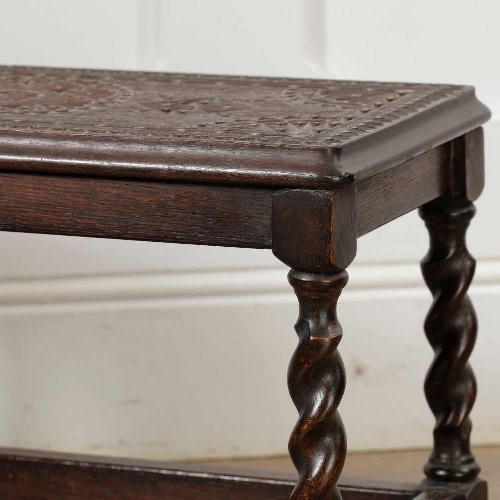 A low dark oak rectangular stool featuring four spiral barley twist legs connected by lower stretchers. View V