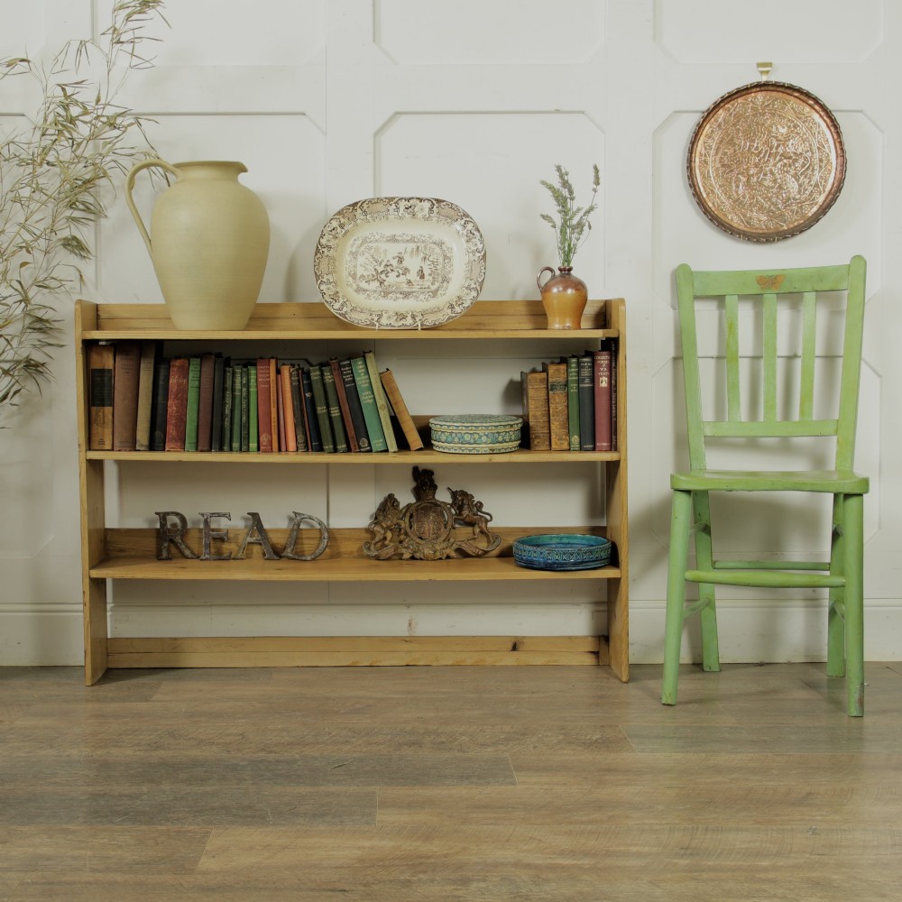 A low three-tier vintage pine open-backed bookshelf with natural timber grain and knots visible throughout. View III