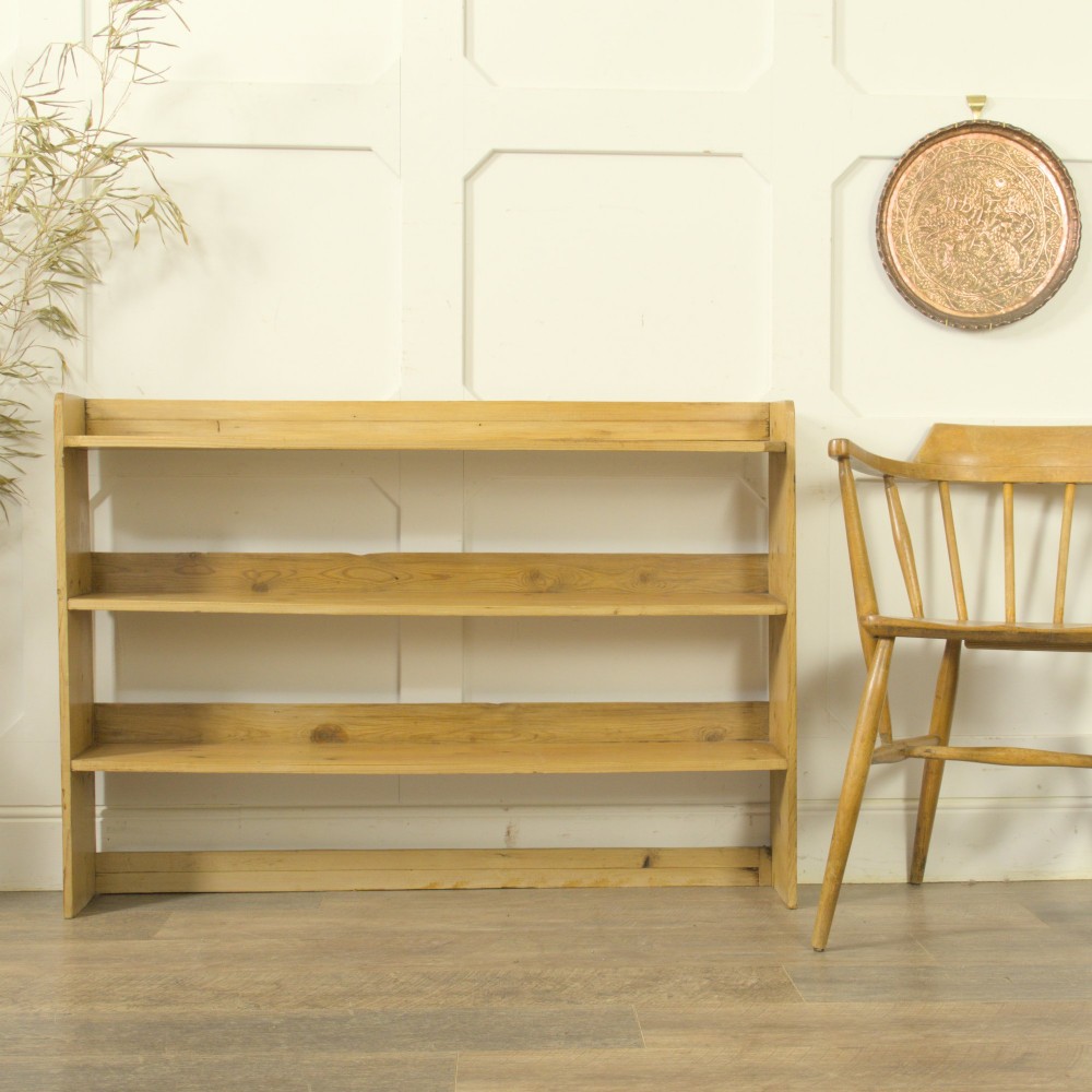 A low three-tier vintage pine open-backed bookshelf with natural timber grain and knots visible throughout. View IV