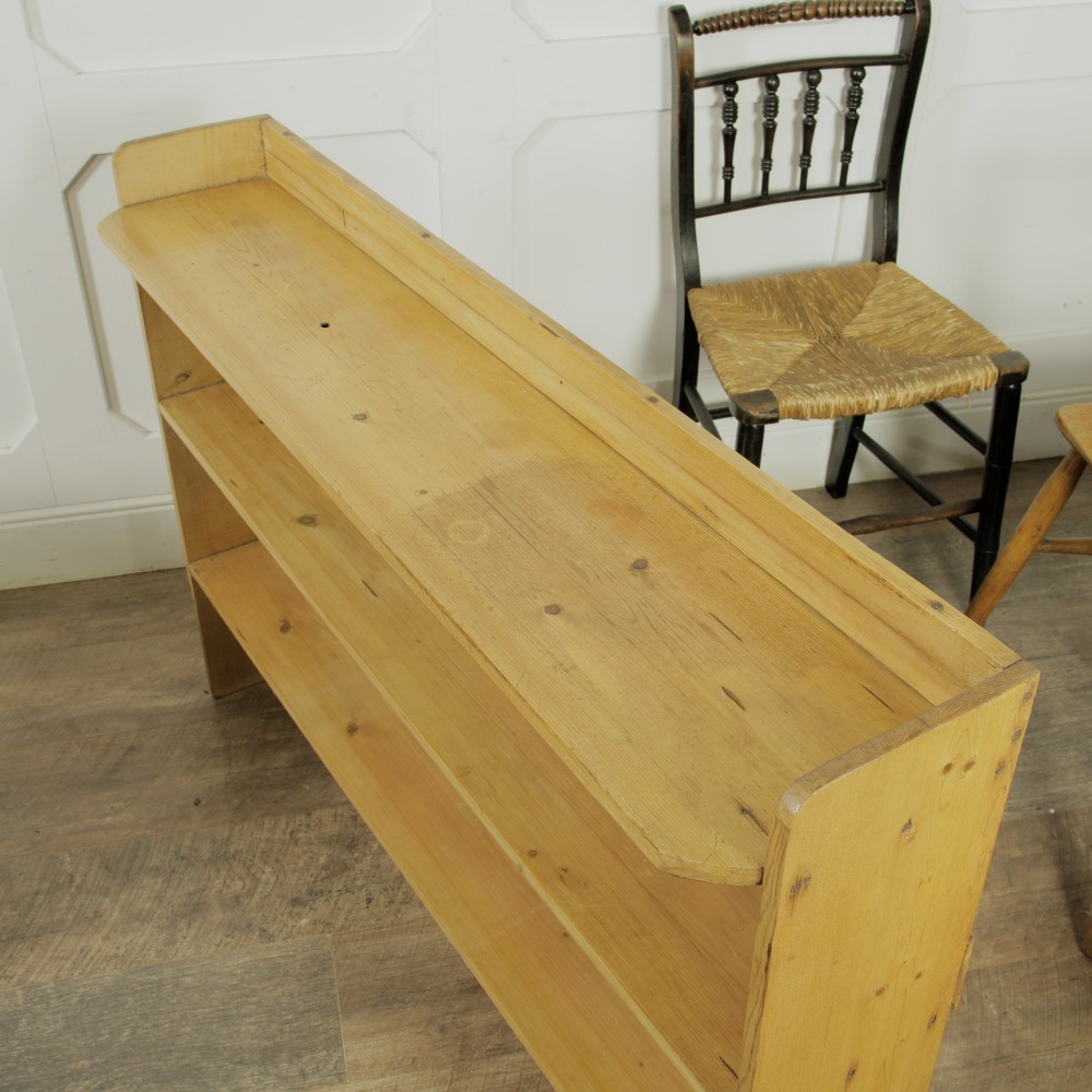 A low three-tier vintage pine open-backed bookshelf with natural timber grain and knots visible throughout. View VI