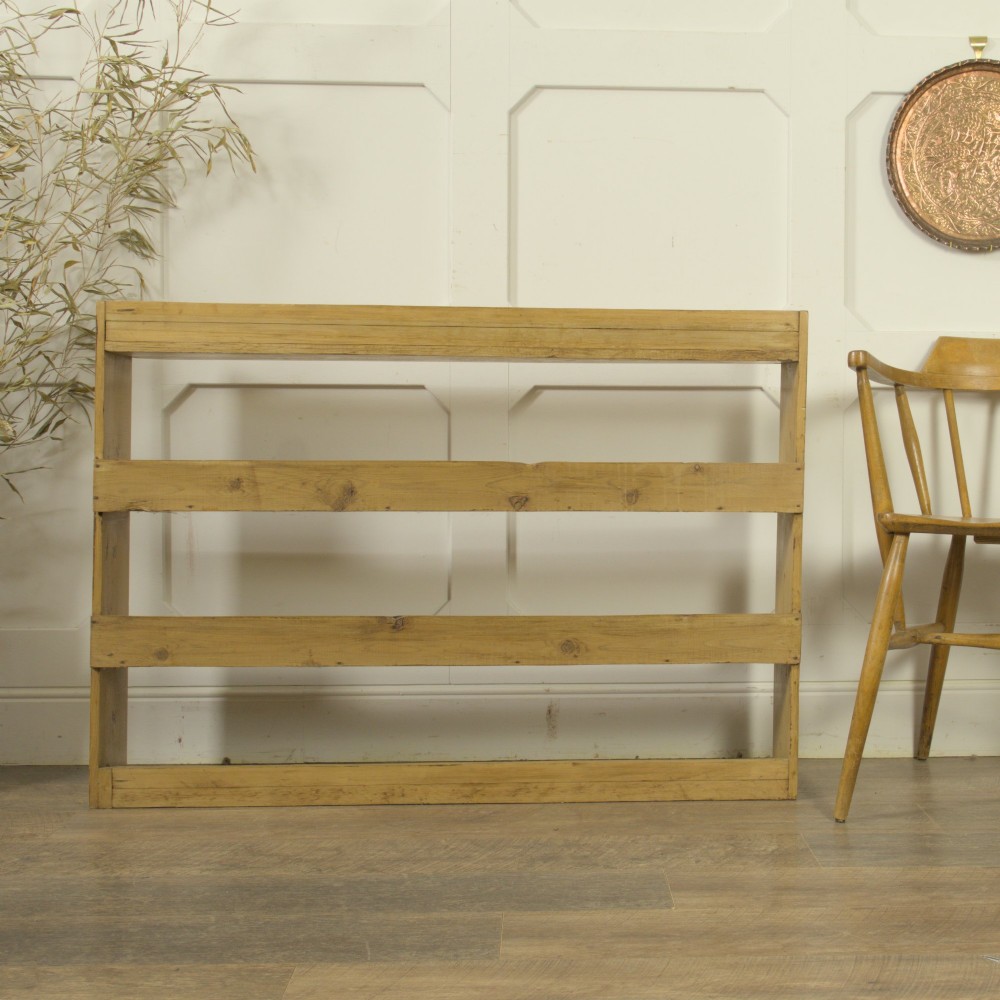 A low three-tier vintage pine open-backed bookshelf with natural timber grain and knots visible throughout. View VIII