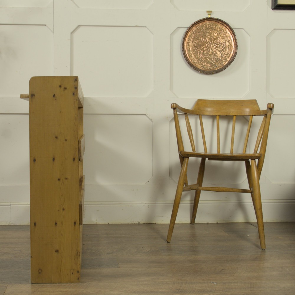 A low three-tier vintage pine open-backed bookshelf with natural timber grain and knots visible throughout. View X