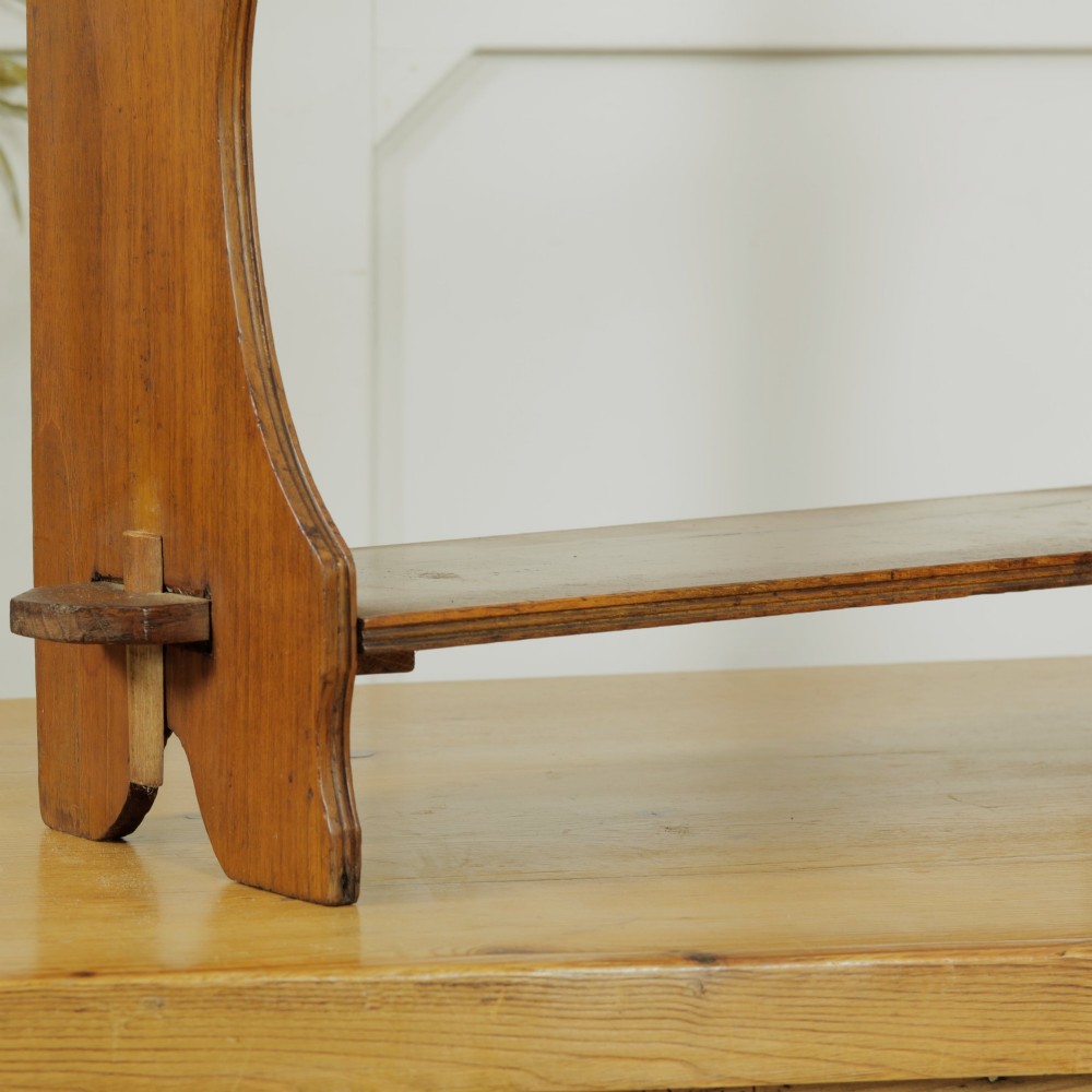 A three-tier warm brown wooden wall shelving unit featuring shaped side supports, wedged tenons, and a carved pierced cresting pediment. View V