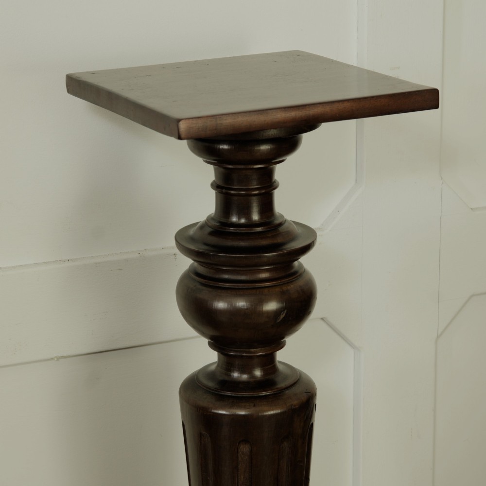 A dark turned mahogany plinth stand featuring a square top and base with a fluted central column. View IV