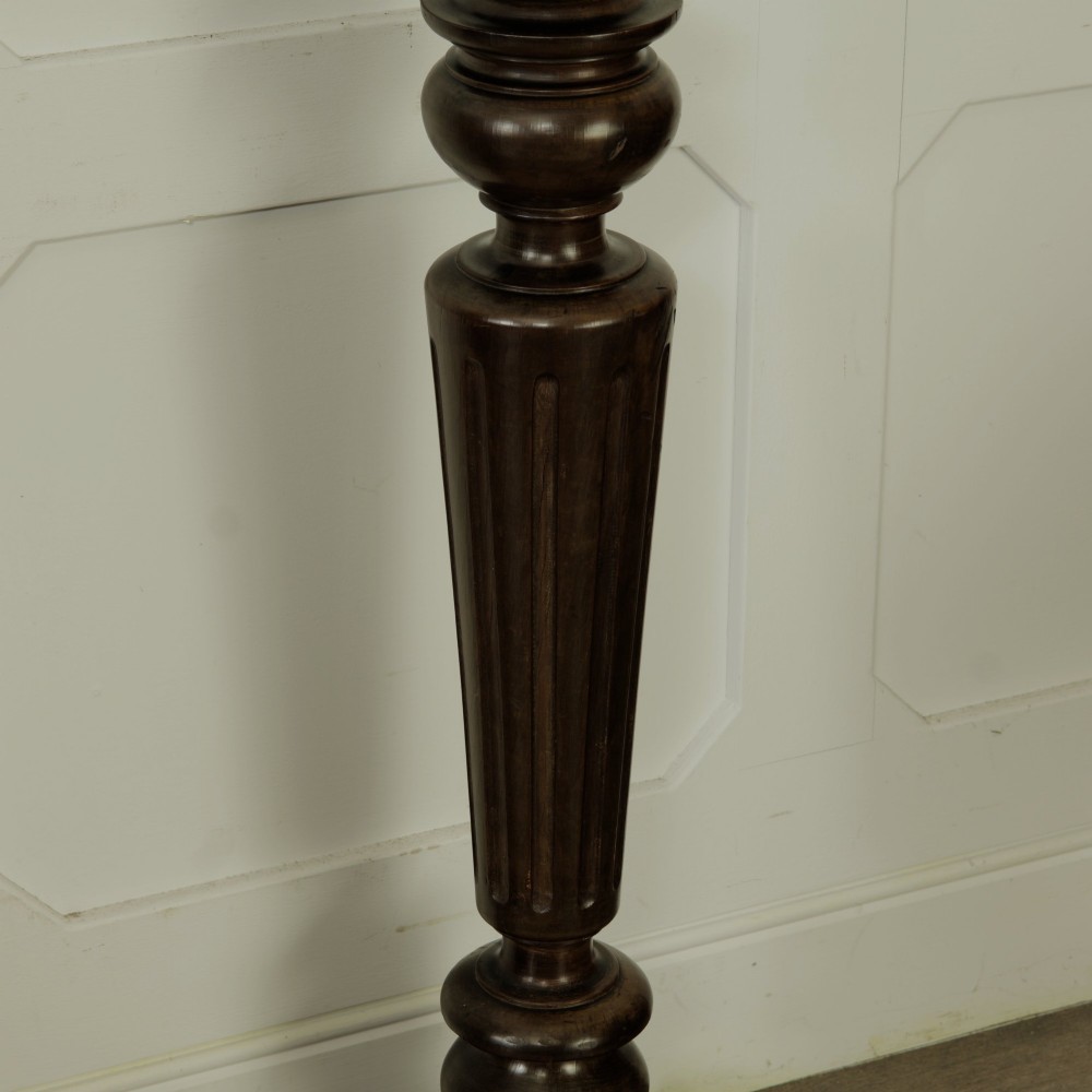A dark turned mahogany plinth stand featuring a square top and base with a fluted central column. View V
