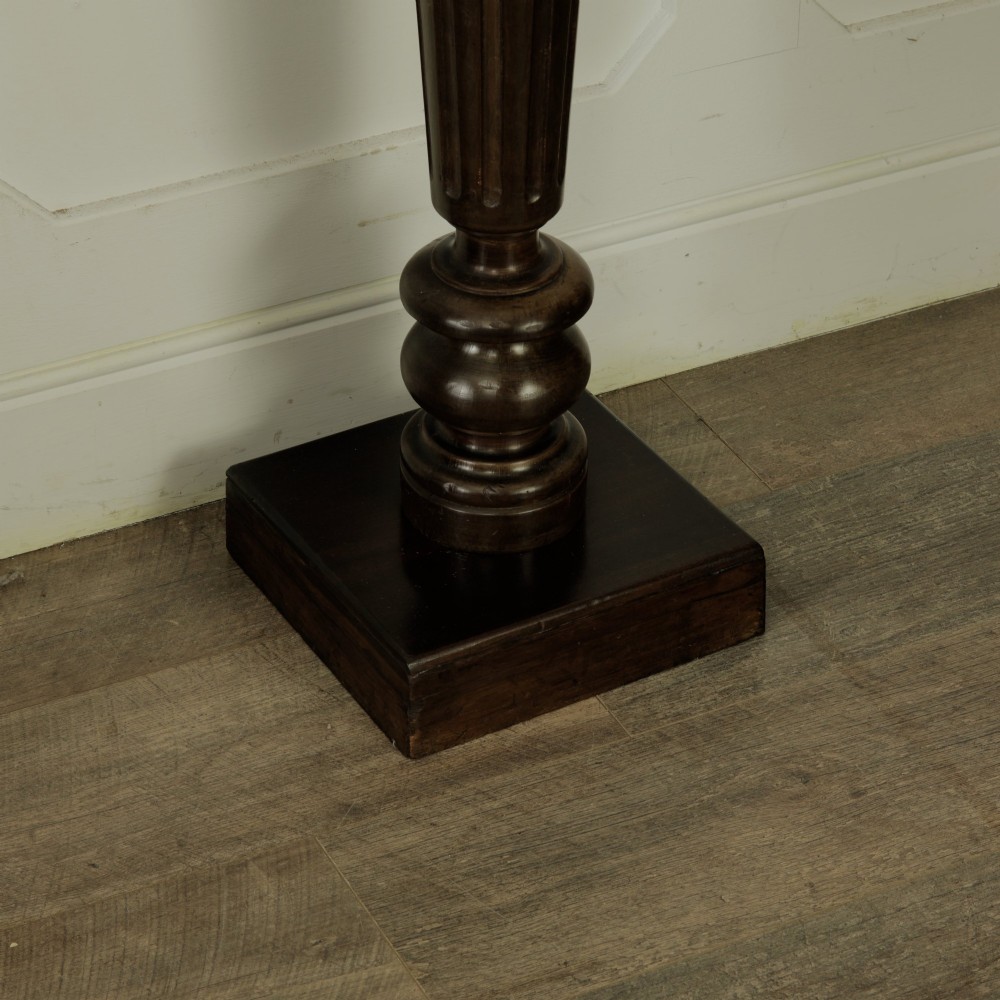 A dark turned mahogany plinth stand featuring a square top and base with a fluted central column. View VI